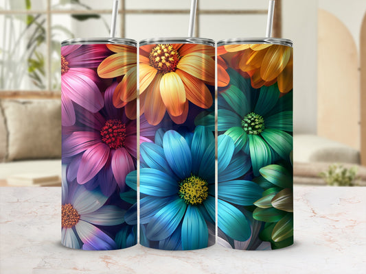 Three colorful floral tumblers with straws, set on a marbled surface.