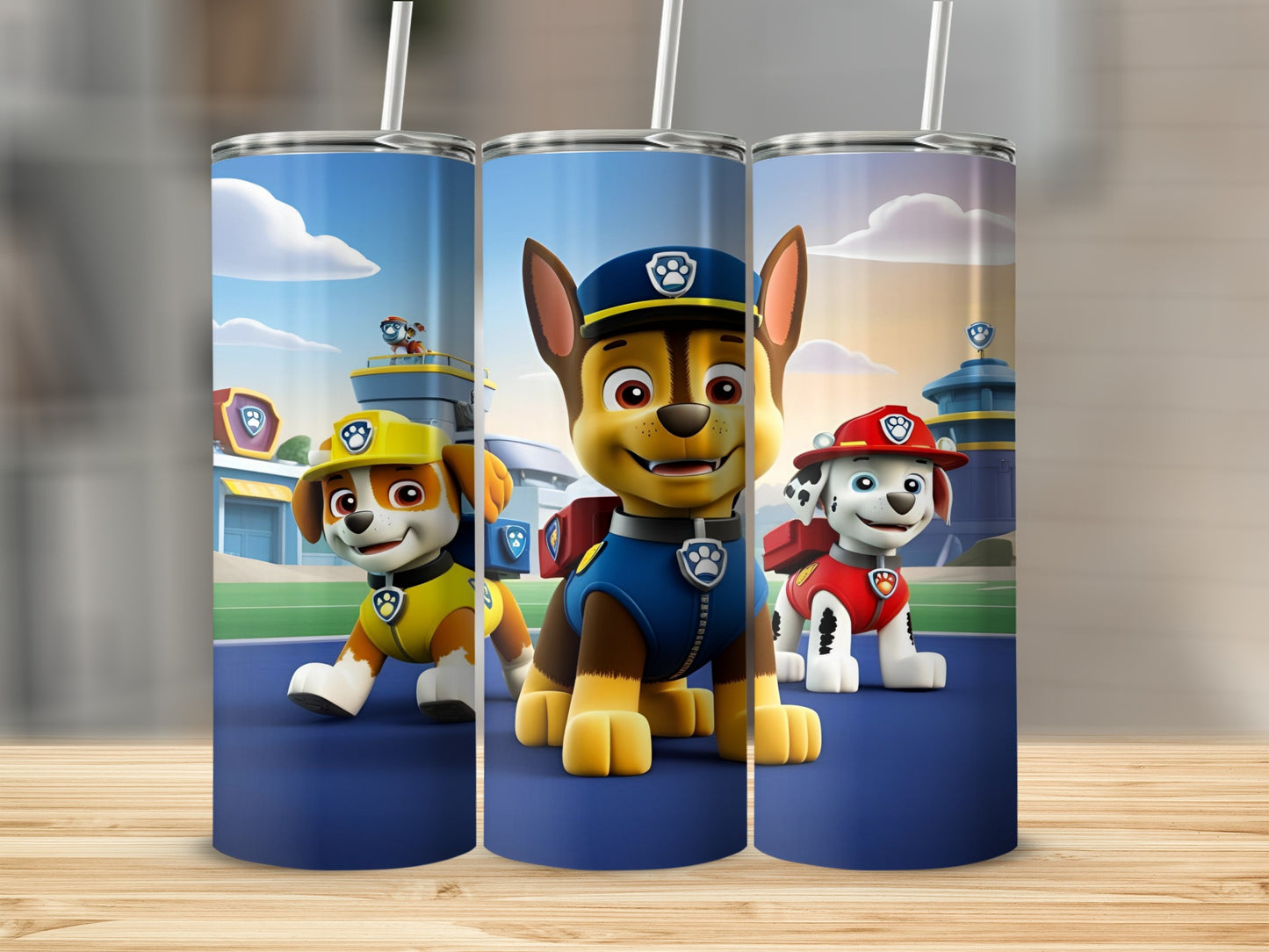 Paw Patrol characters Chase, Marshall, and Ryder in uniform on a blue surface.