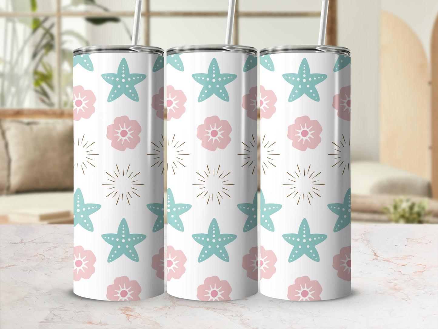 Three tumblers with starfish and floral patterns on a white surface.