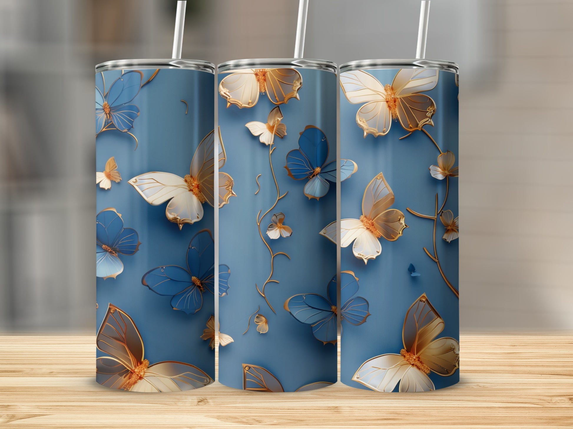 Three blue tumblers with gold and white butterfly designs.