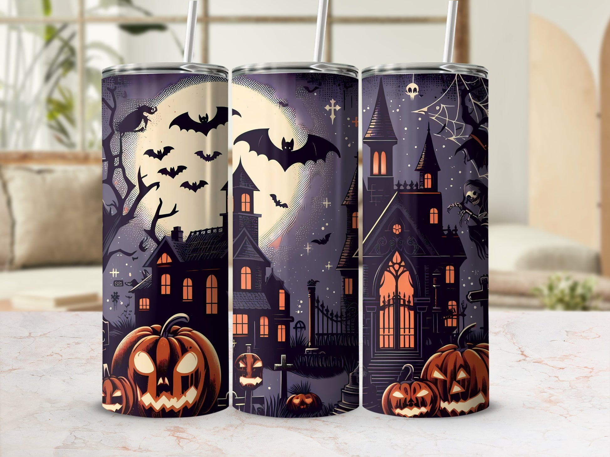 Three tumblers with Halloween designs featuring haunted houses, pumpkins, and bats.