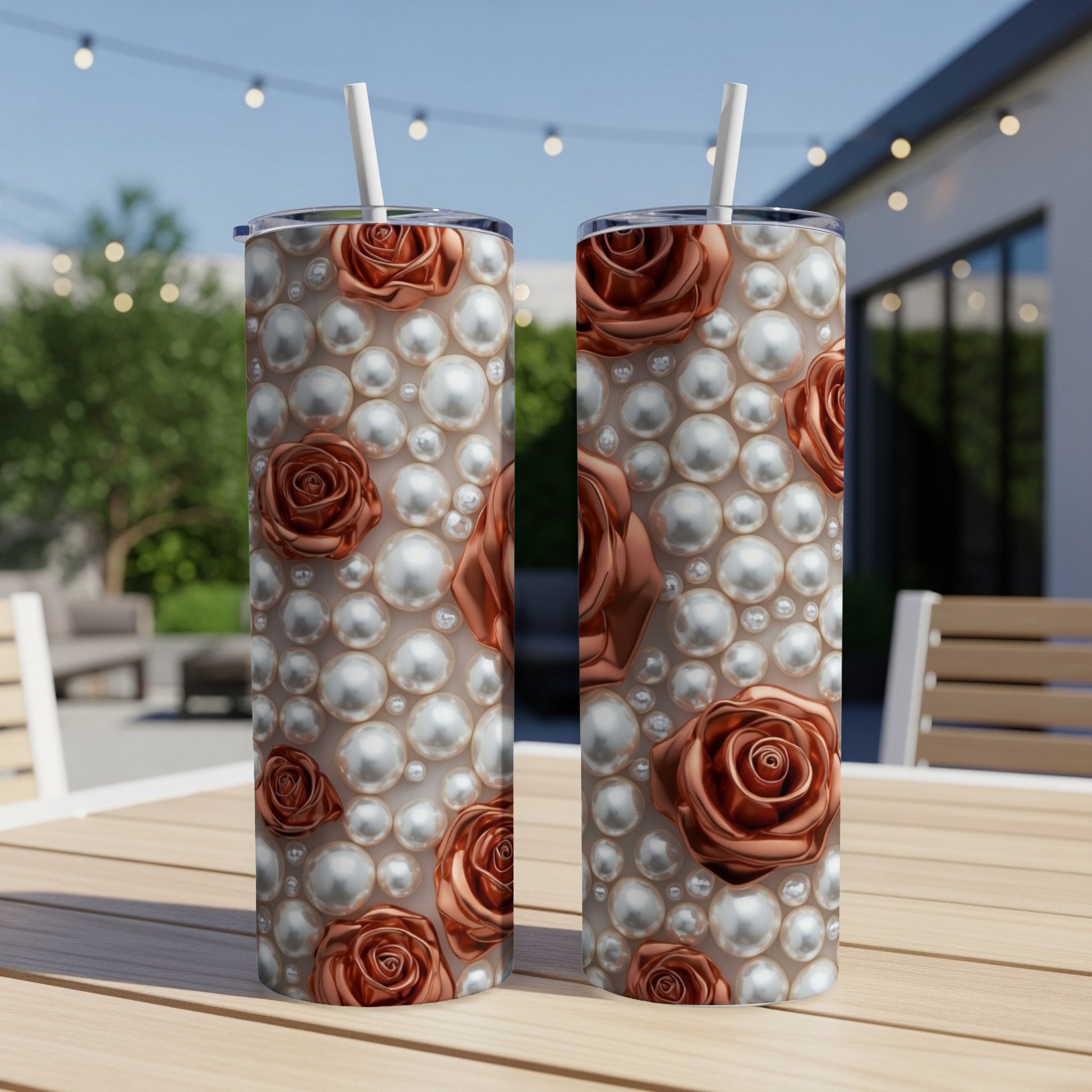 Two tumblers with rose and pearl pattern on a table outdoors.