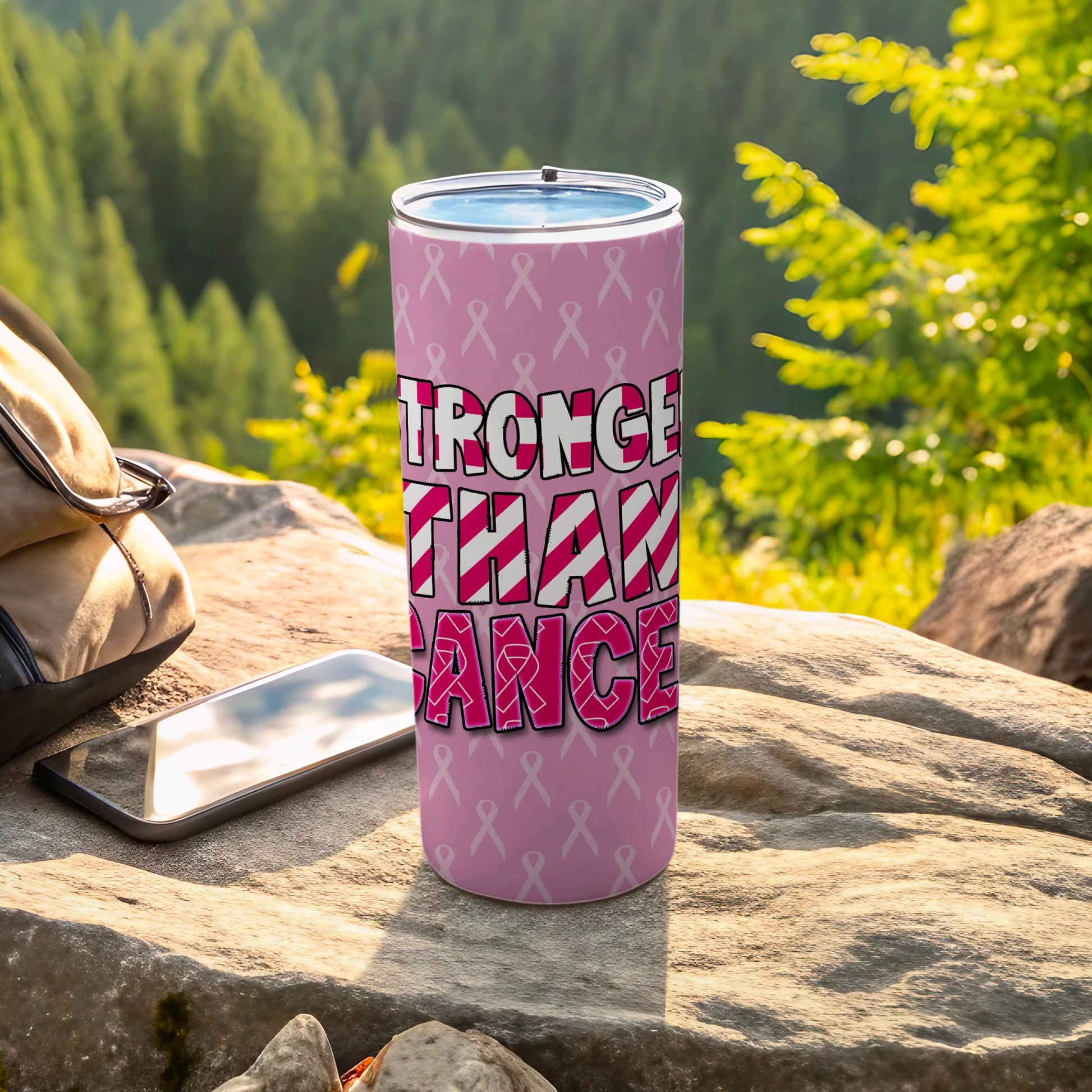 Pink tumbler with "Stronger Than Cancer" text and ribbon pattern.