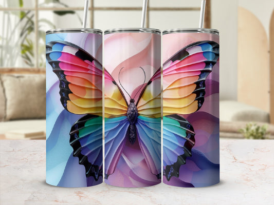 Three tumblers with rainbow butterfly wings on a blurred background.