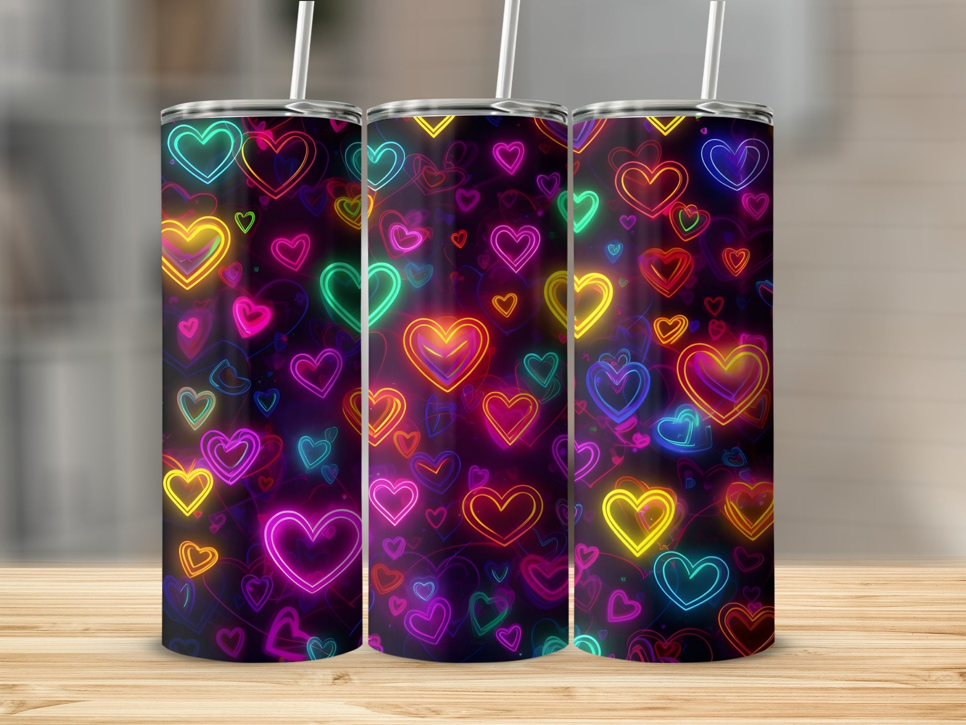 Three tumblers with a vibrant neon heart pattern on a wooden surface.