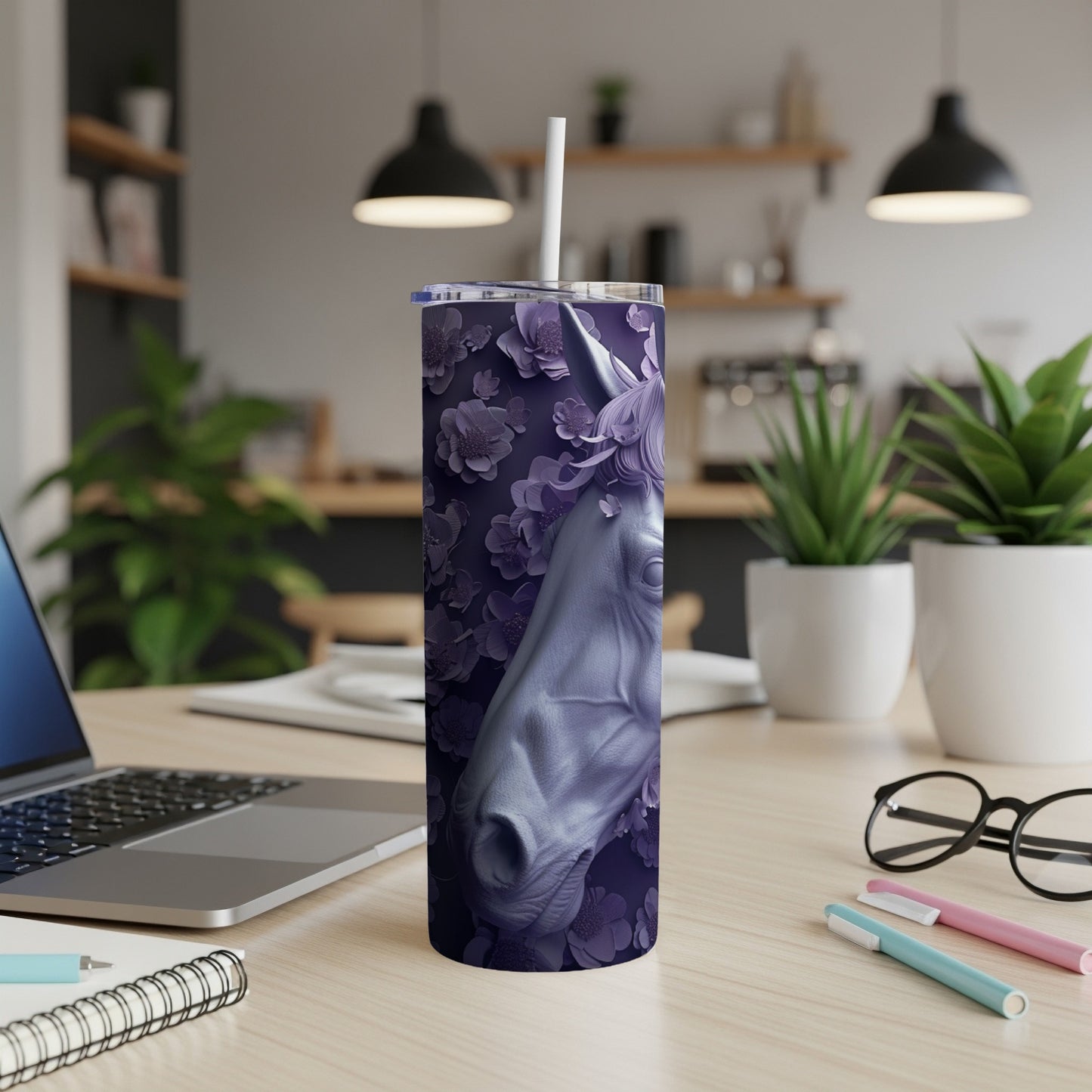 Purple unicorn tumbler with floral pattern on a desk.