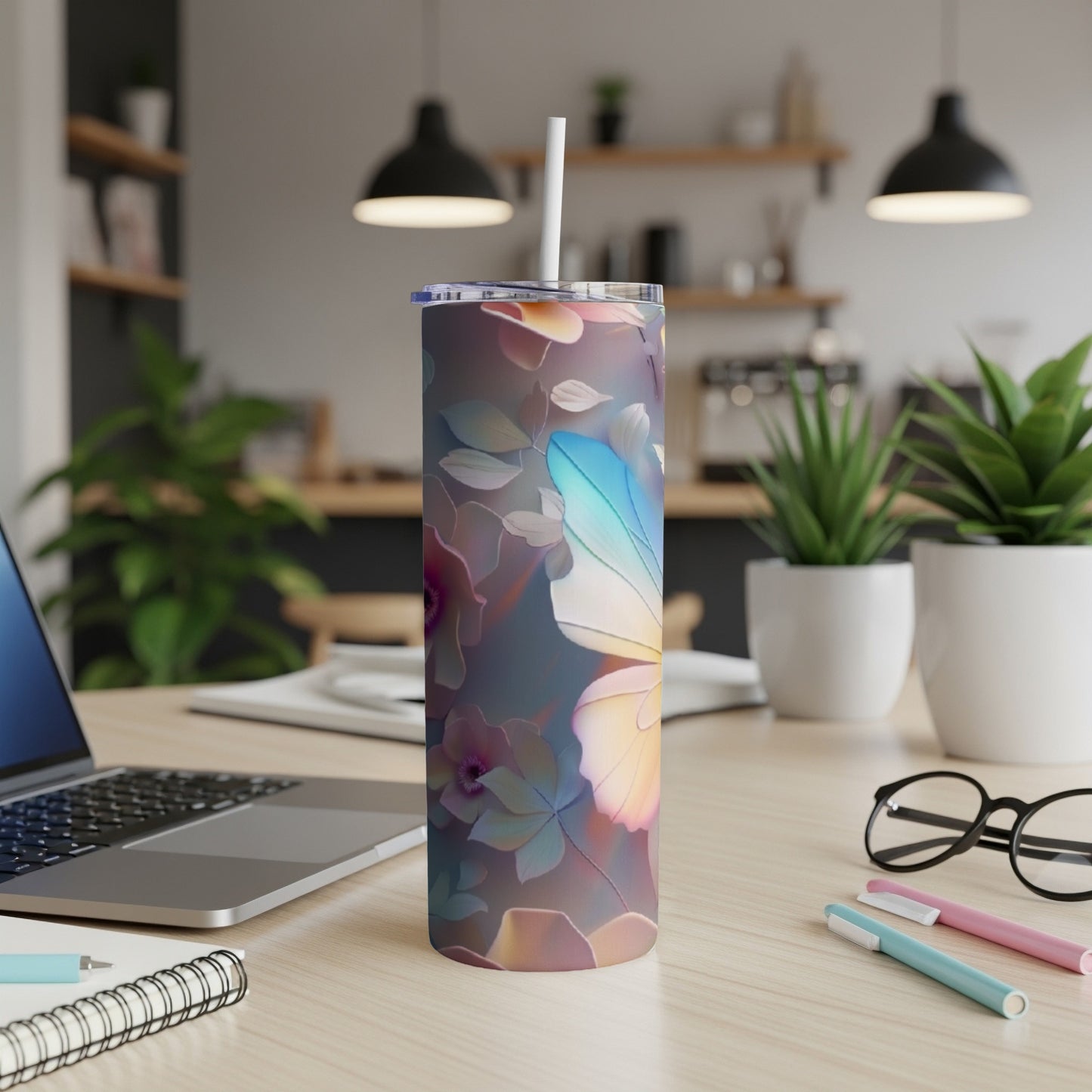 Floral butterfly patterned tumbler with a white straw on a desk.