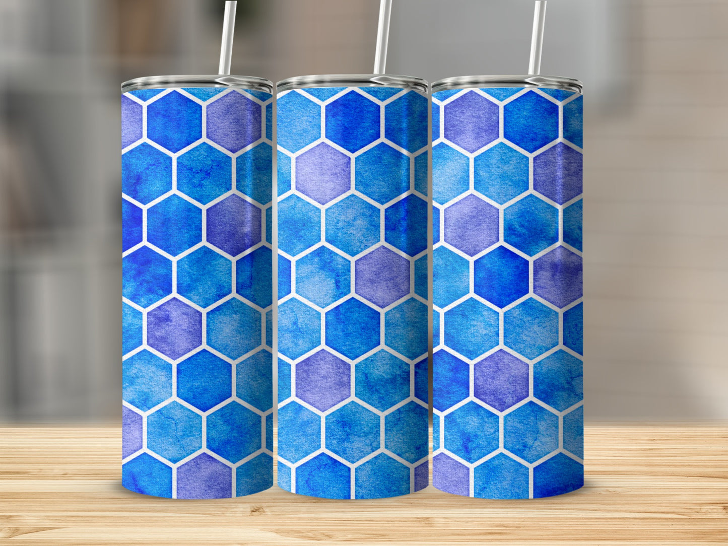 Three tumblers with a blue watercolor hexagon pattern on a wooden surface.