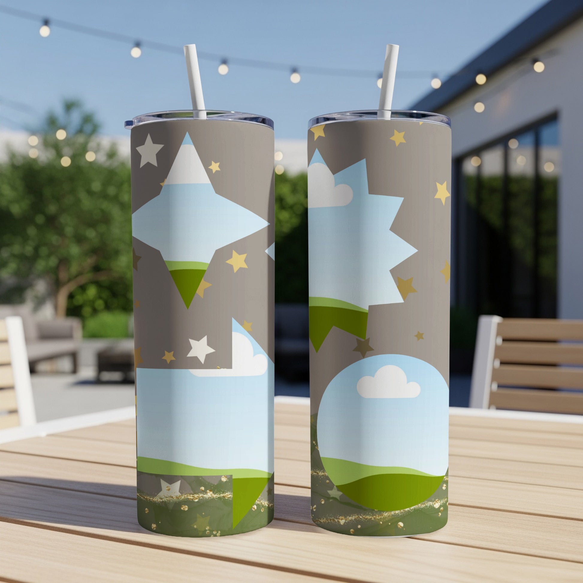 Two skinny tumblers with stars, clouds, and green rolling hills design.