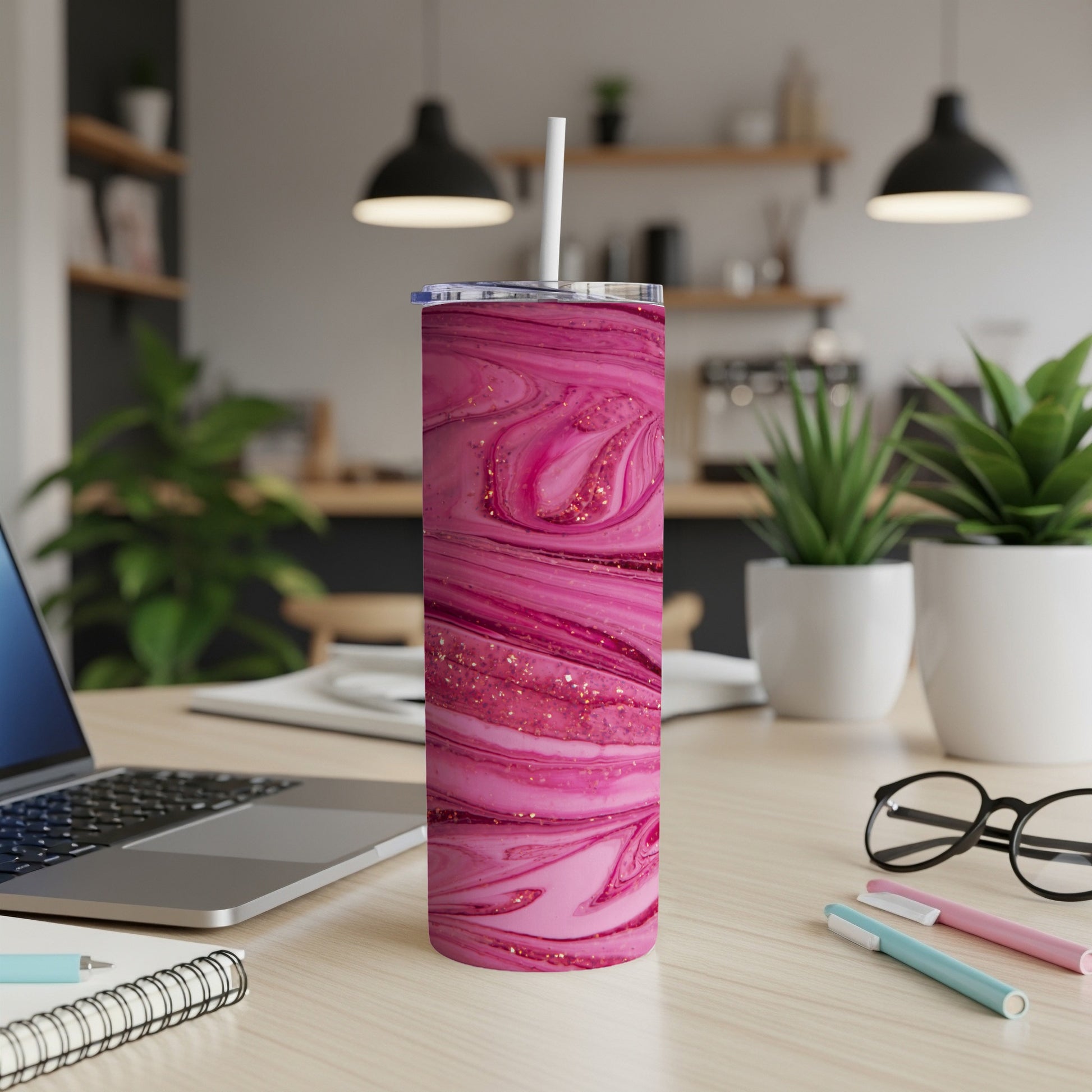 Pink and gold marble tumbler with white straw on a wooden desk.
