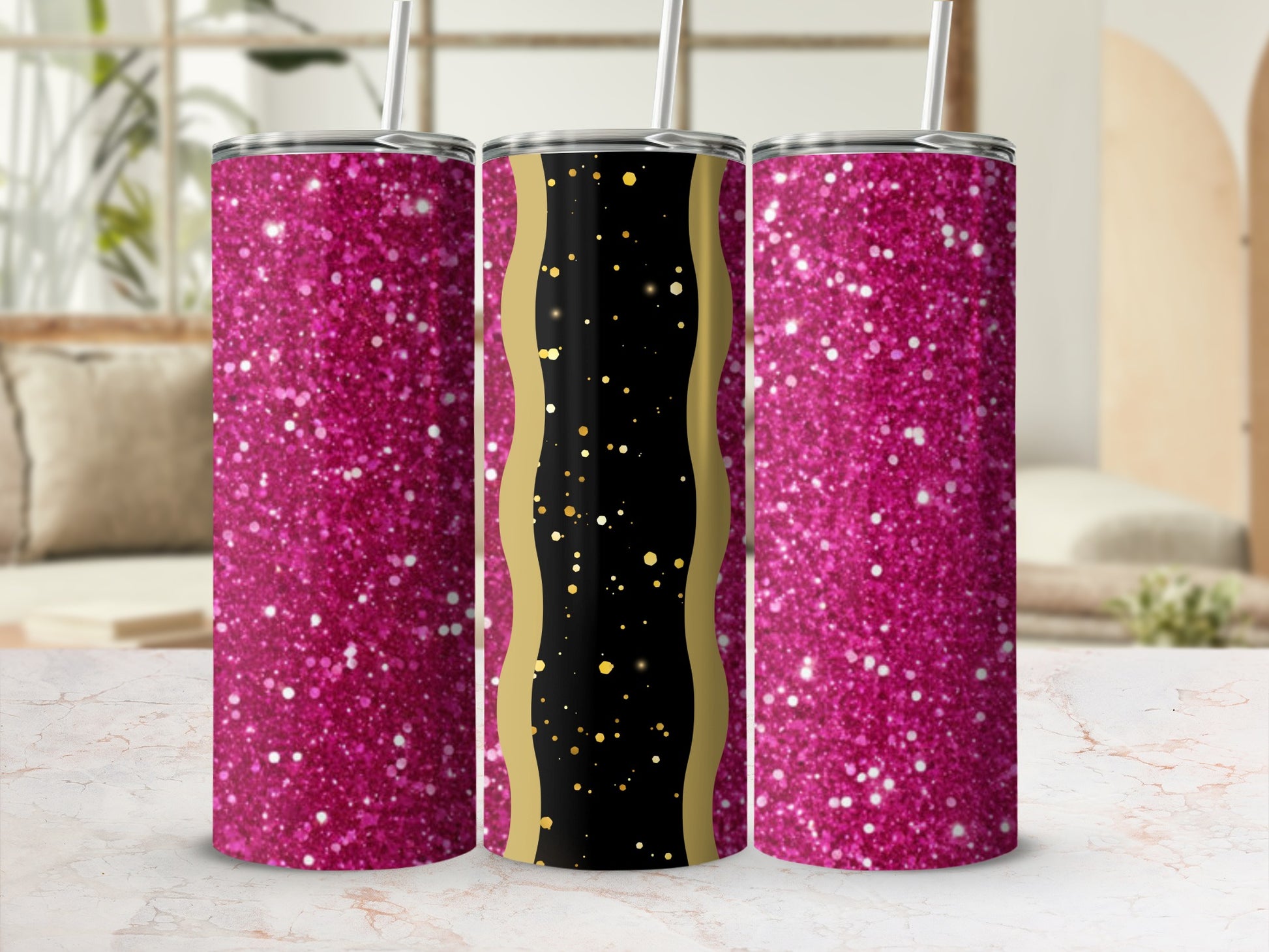 Three glitter tumblers with gold accents on a marble surface.
