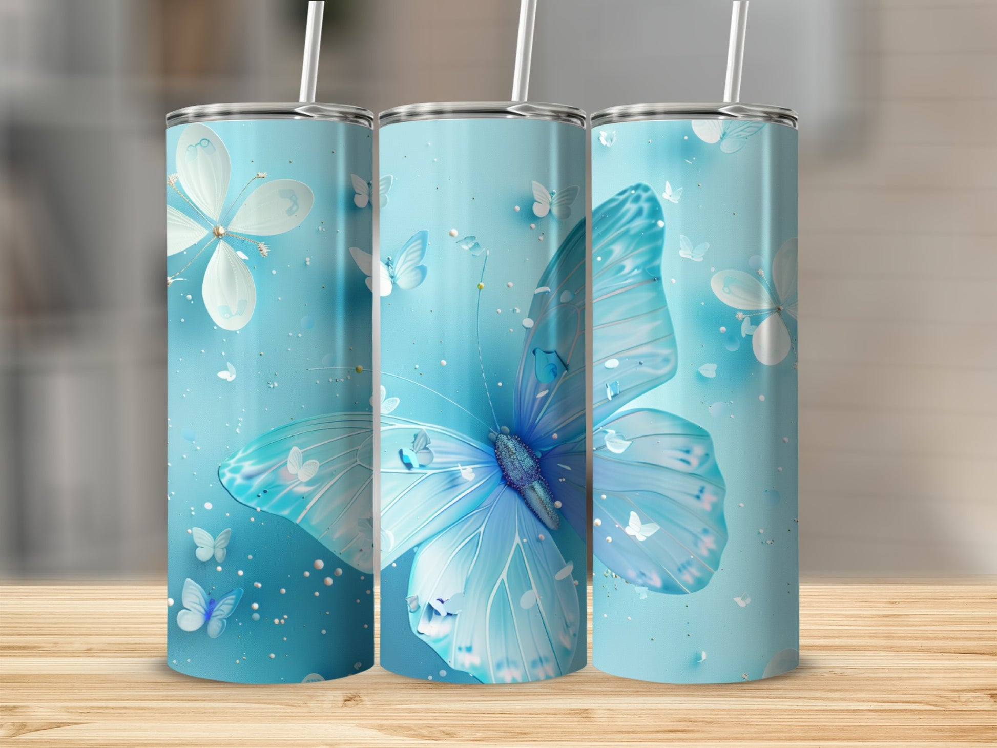 Three blue tumblers with large butterfly and small butterfly designs.