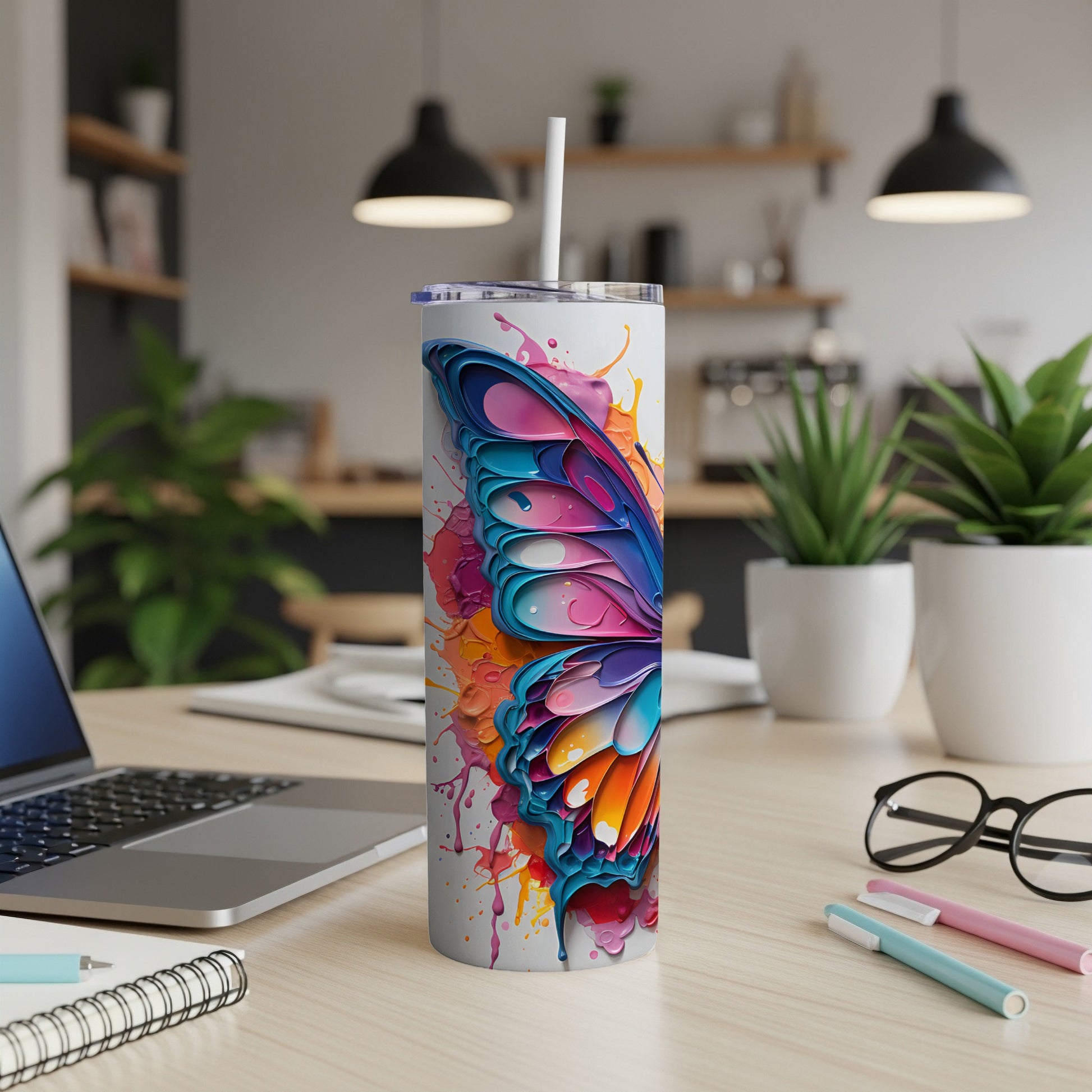 Tumbler featuring a colorful butterfly wing design with paint splatters.