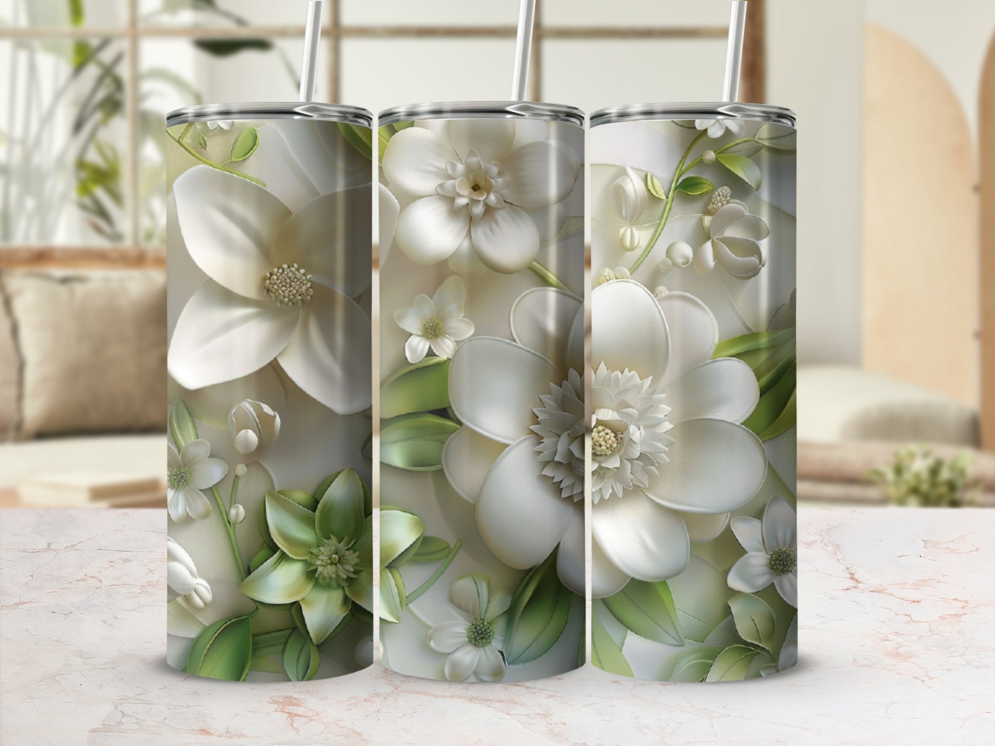 Three white magnolia flowers with green leaves wrap around a tumbler.