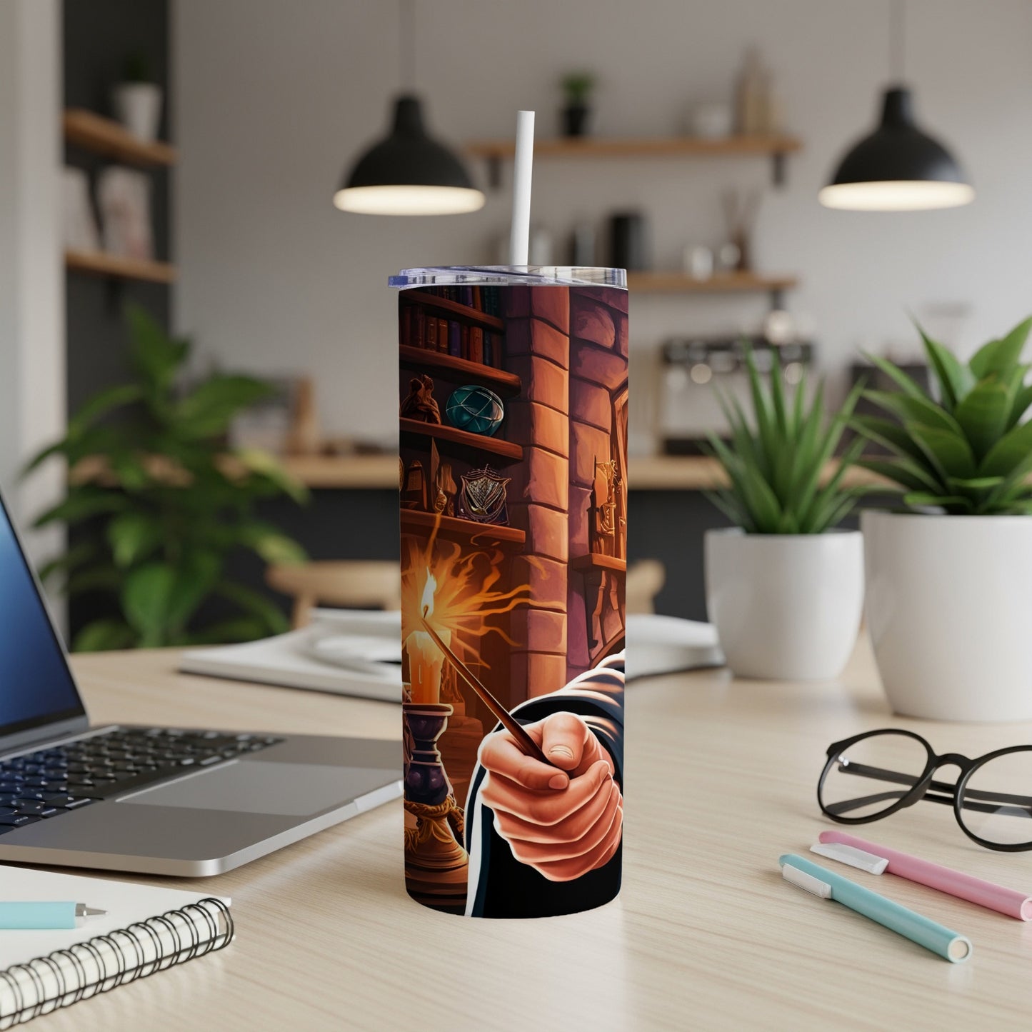 Harry Potter-themed tumbler with magic wand and books on a desk.