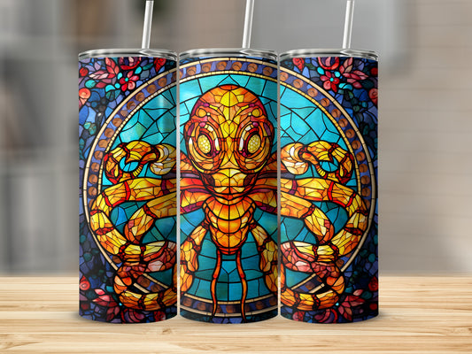Stained glass alien with large eyes and prominent arms on a tumbler.