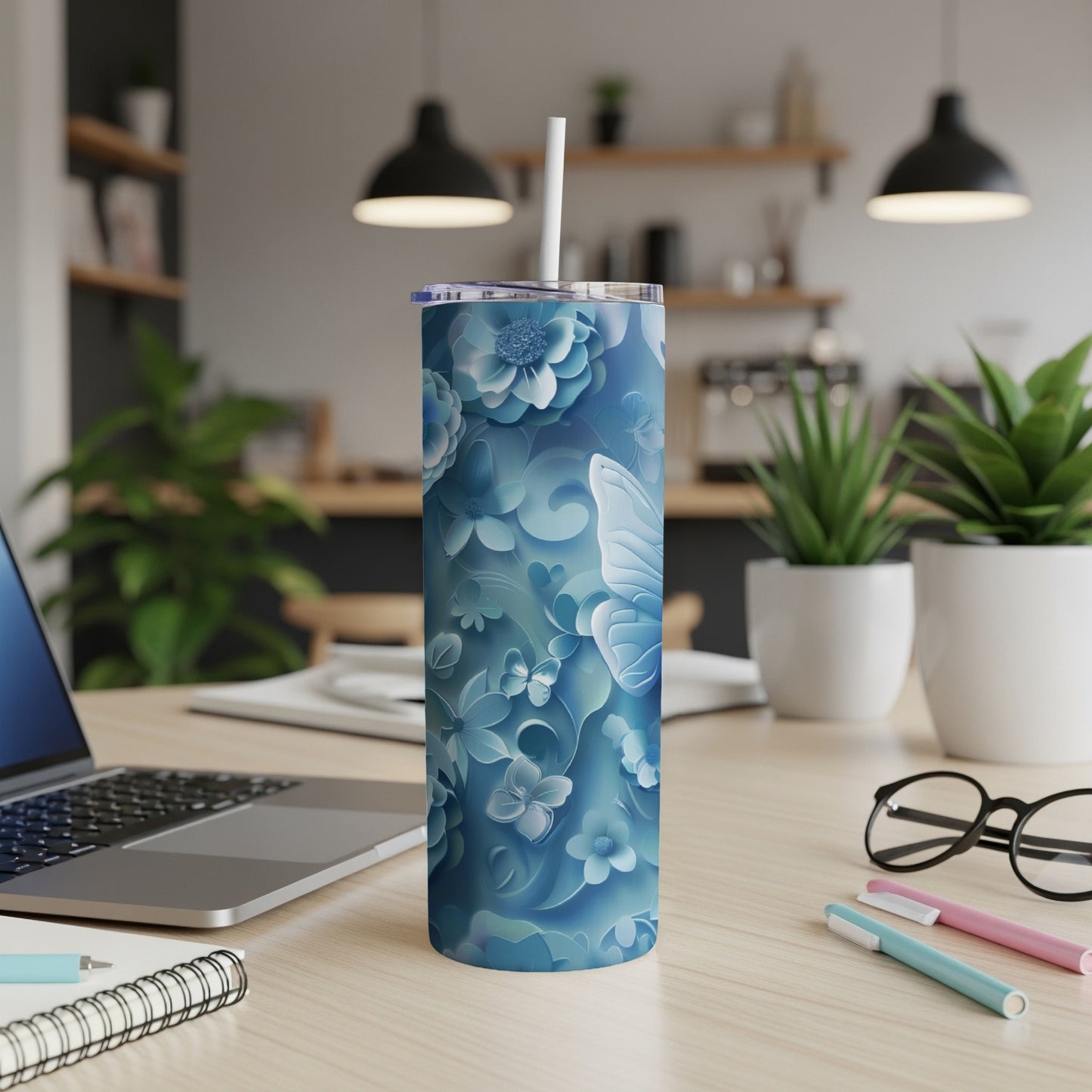 Blue floral and butterfly pattern skinny tumbler with white lid and straw.