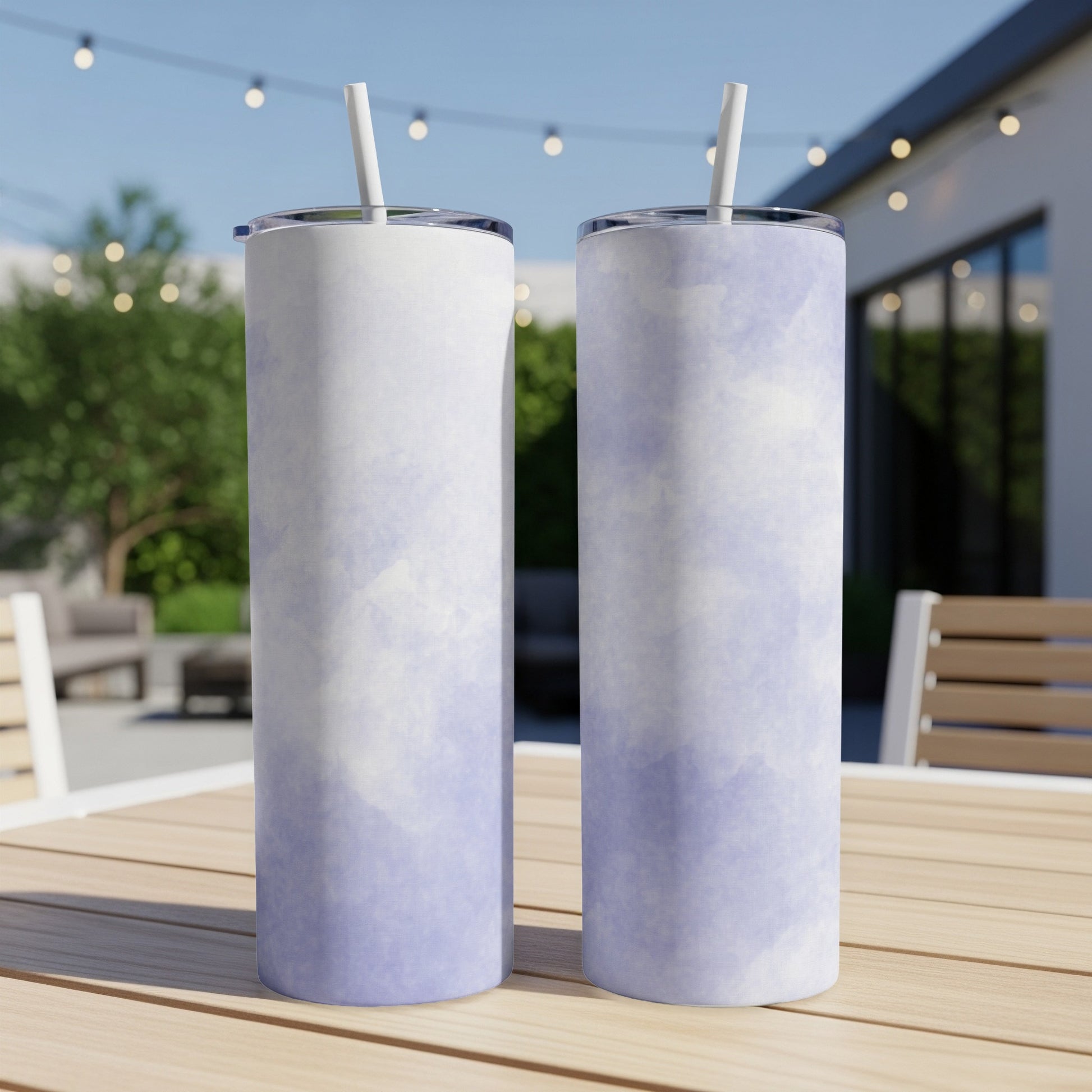 Two tall tumblers with a purple and white watercolor design stand on a table.