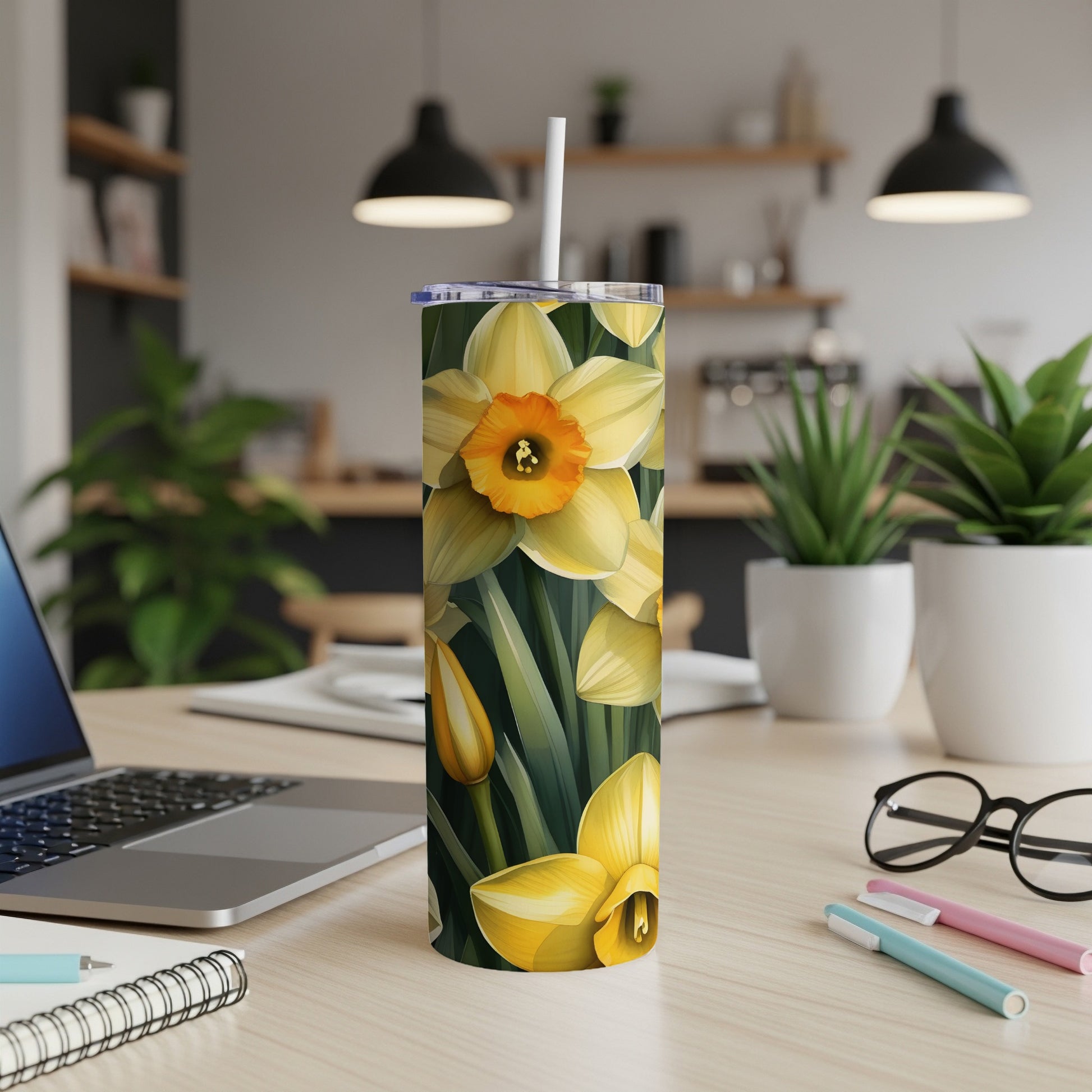Yellow daffodils with green leaves pattern on a skinny tumbler with a white straw.