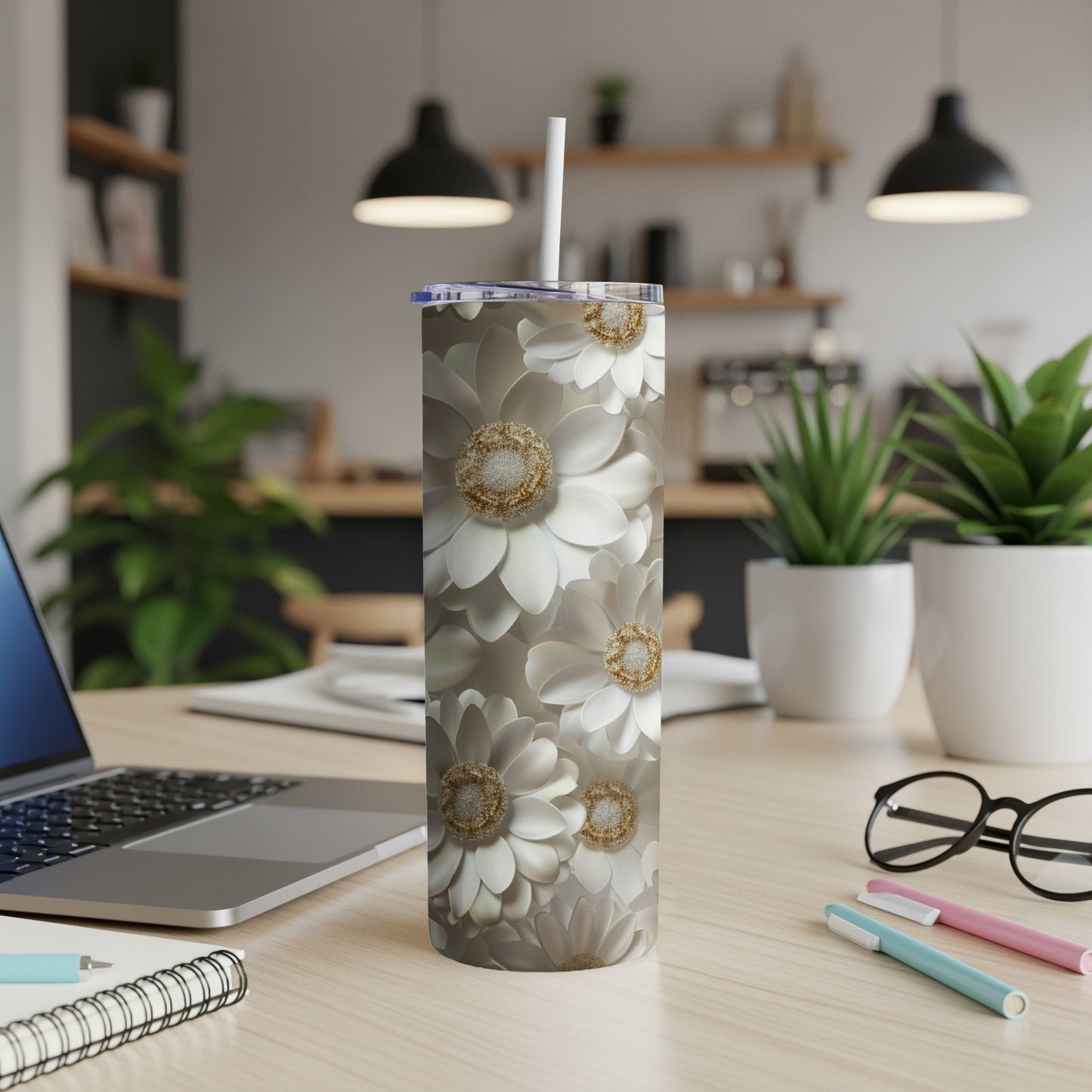 White floral pattern tumbler with straw on a desk.