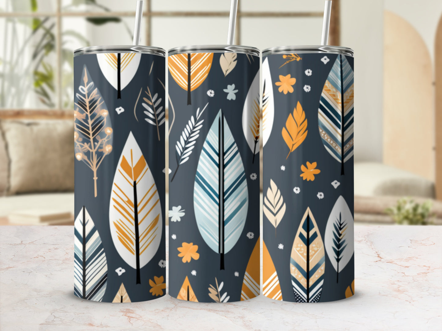 Three tall tumblers with a stylized feather and leaf pattern on a marble surface.
