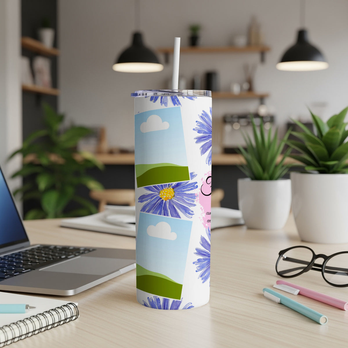 White tumbler with blue flowers, sky, and green hill photo collage.
