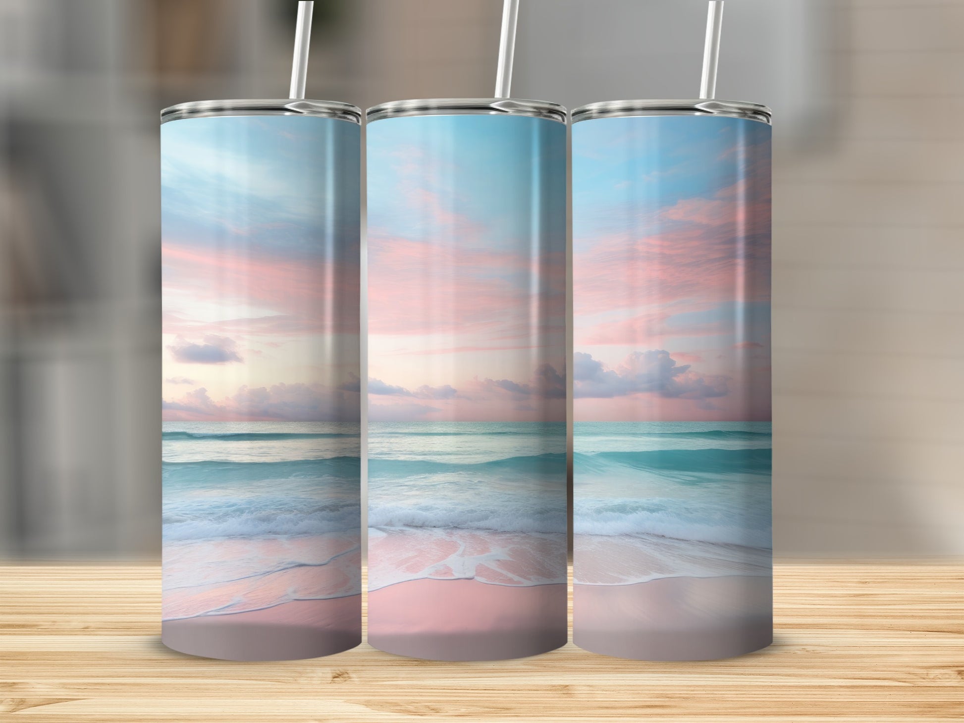 Three tumblers with a beach sunset design, sitting on a wooden surface.