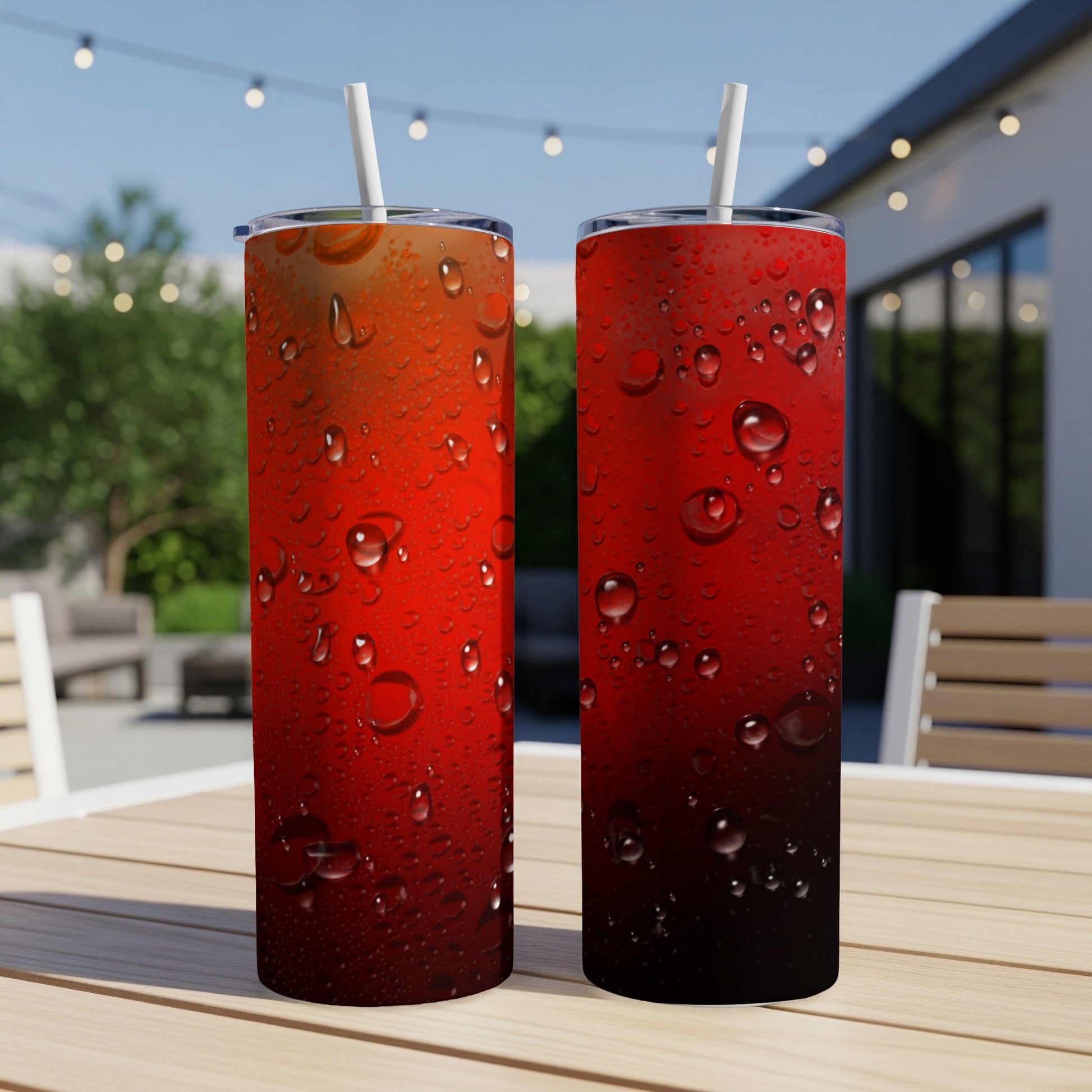 Two red gradient tumblers with water droplets and straws on a table.