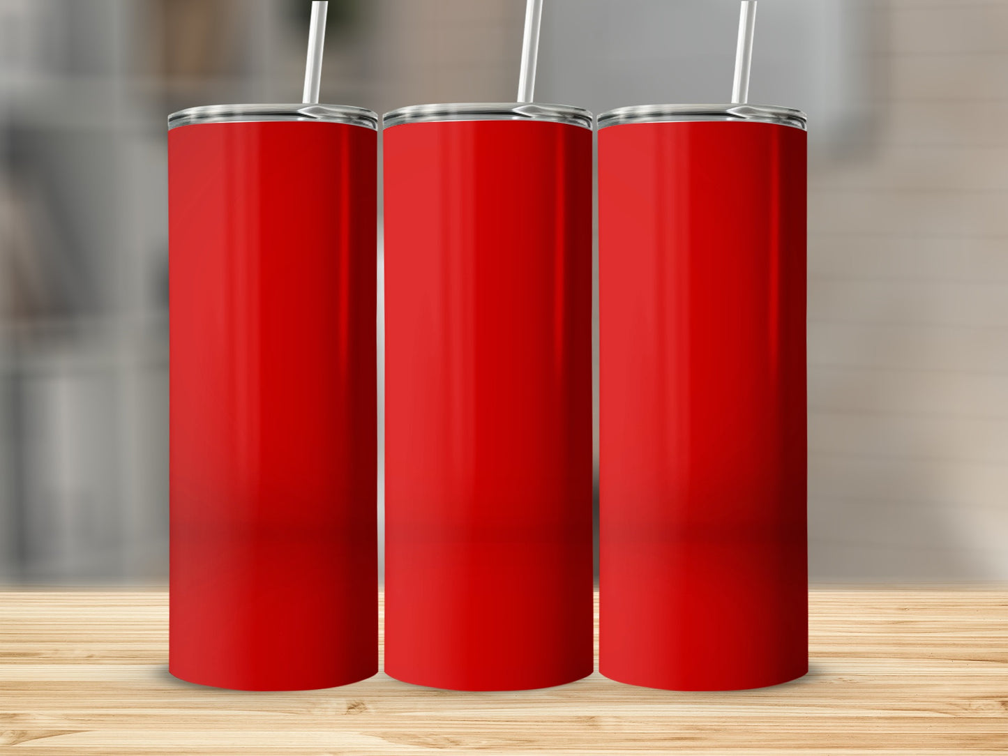 Three red tumblers with white straws stand on a wooden surface.