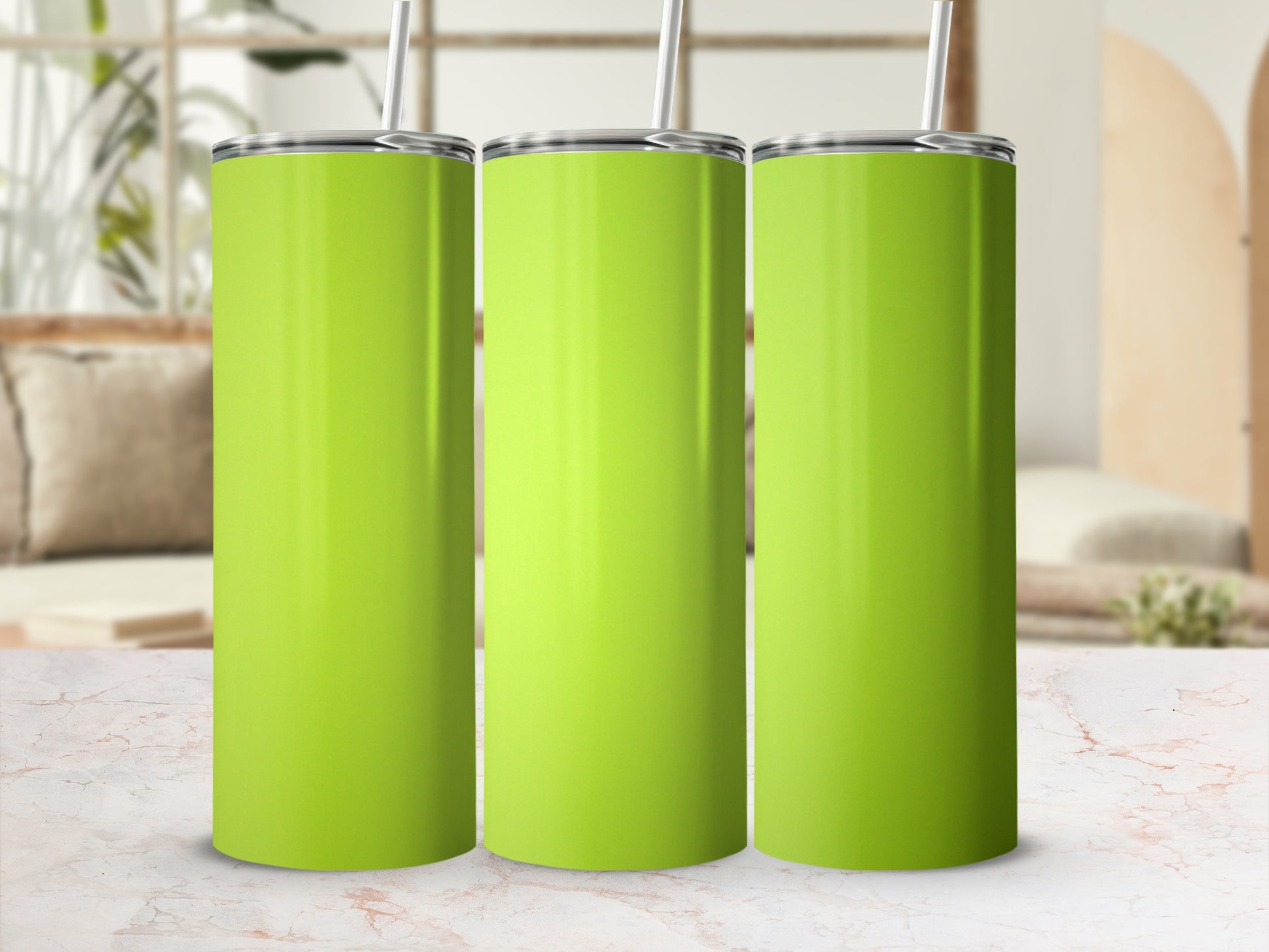 Three lime green tumblers with straws stand side-by-side on a marble surface.