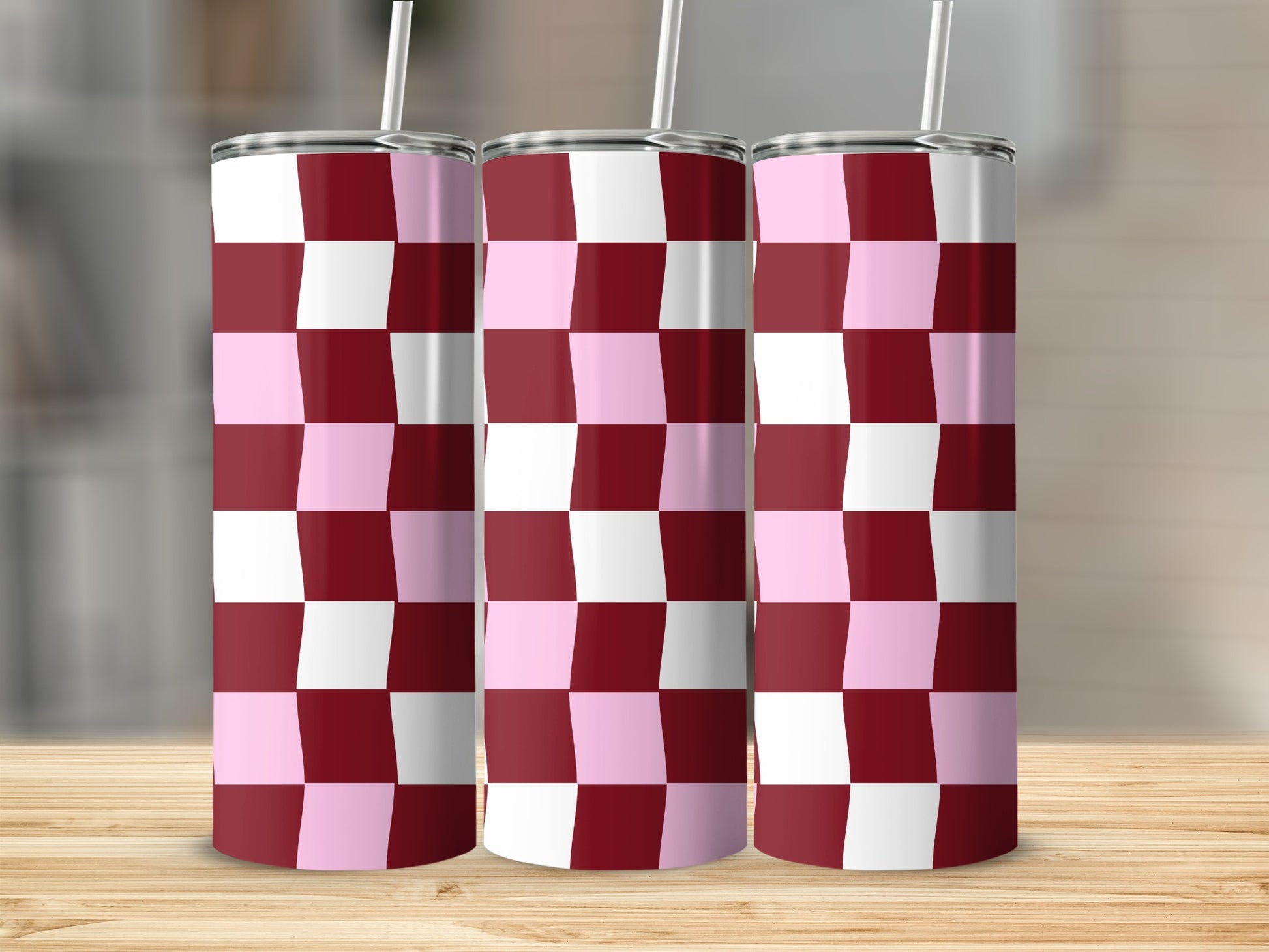 Three tumblers with a pink and burgundy checkerboard pattern on a wooden surface.