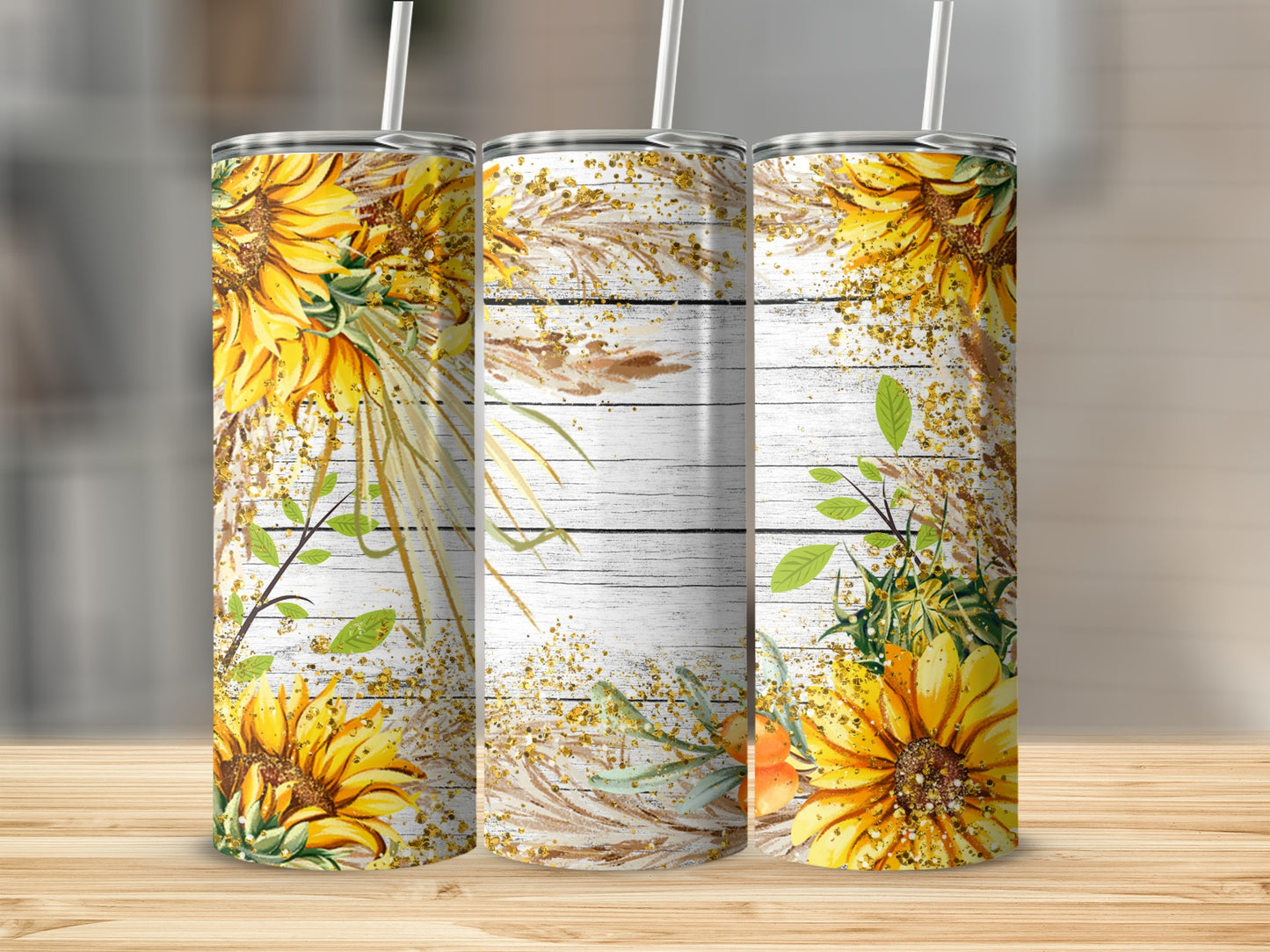 Three tumblers with sunflowers and dried grass design on wood background.