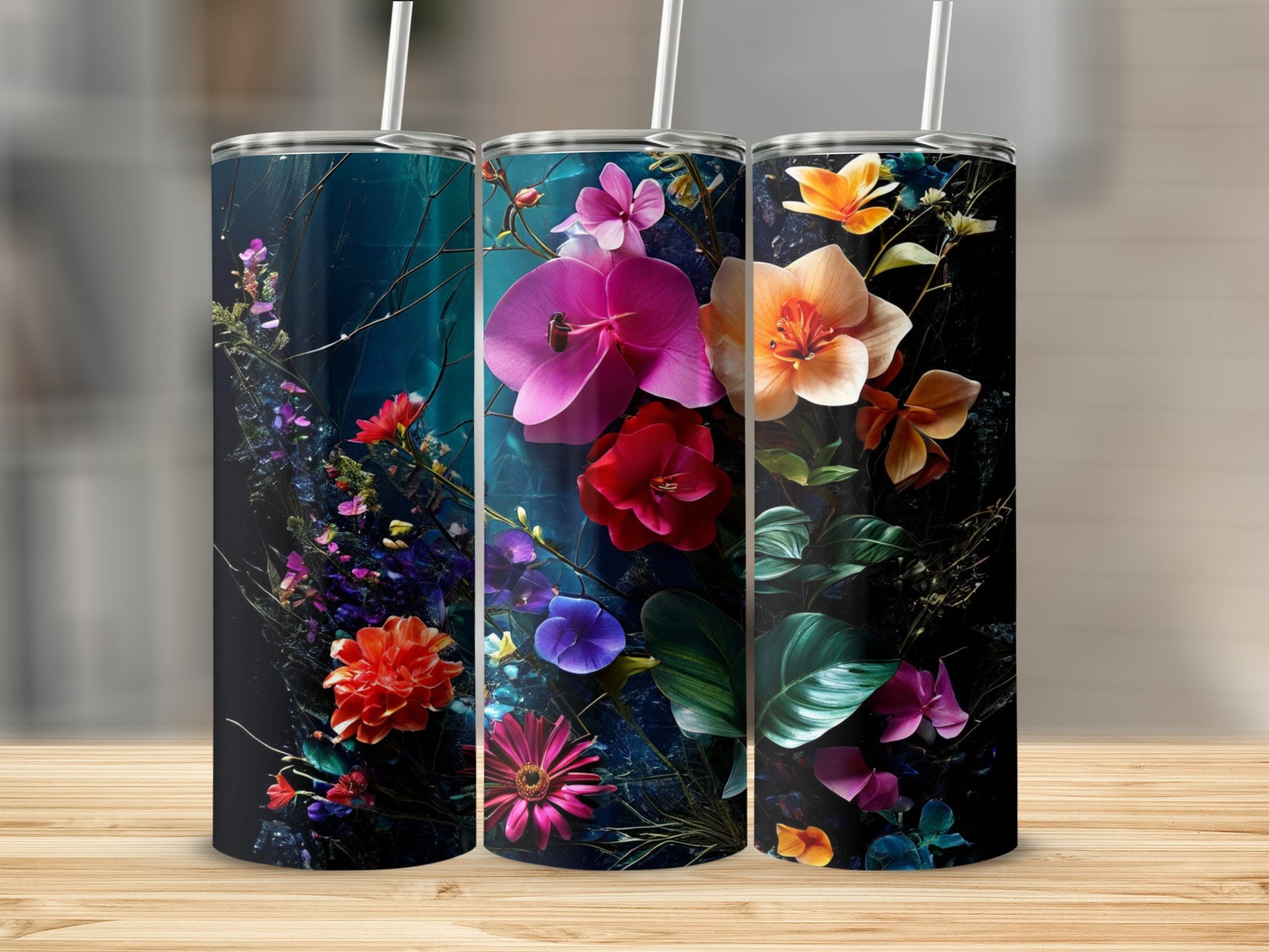 Three tumblers with vibrant floral designs against a dark background.