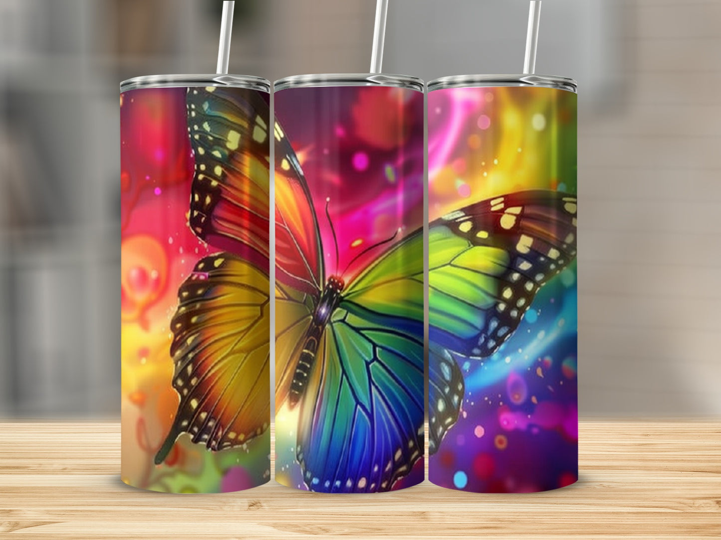 Three tumblers with colorful butterfly and abstract light designs.