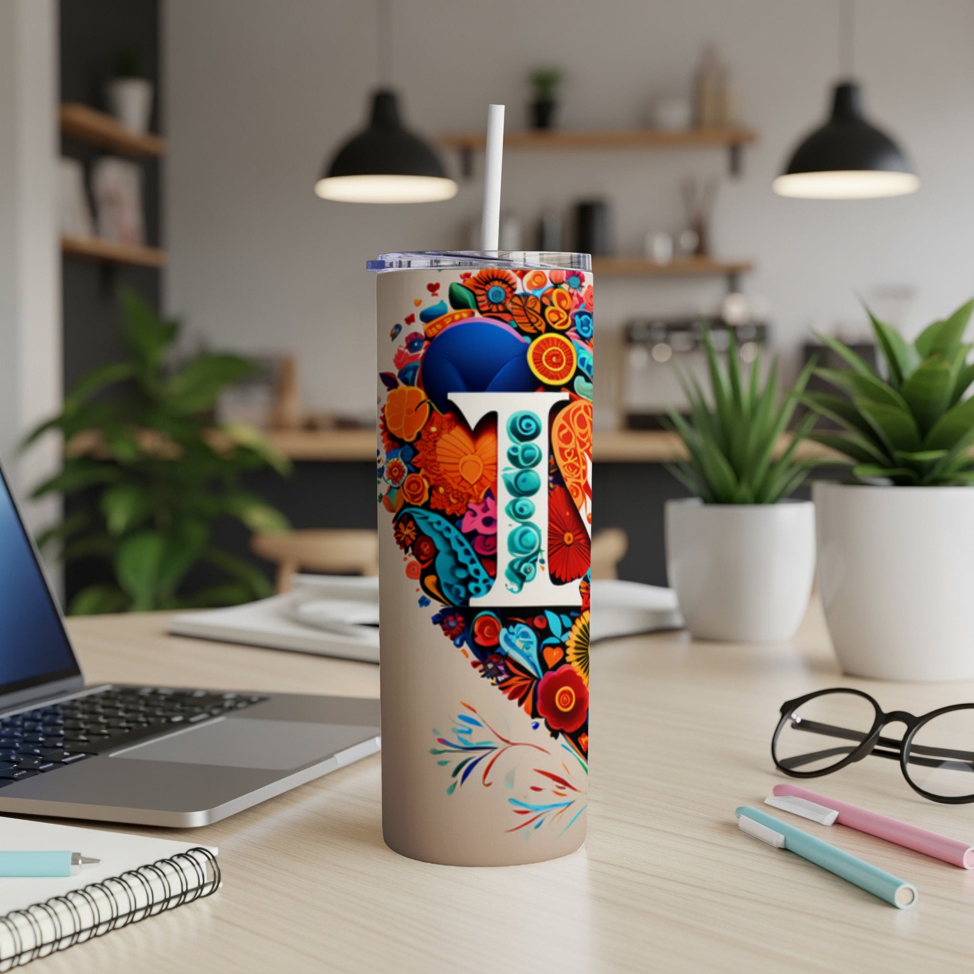 Tall tumbler with colorful floral pattern and letter T.
