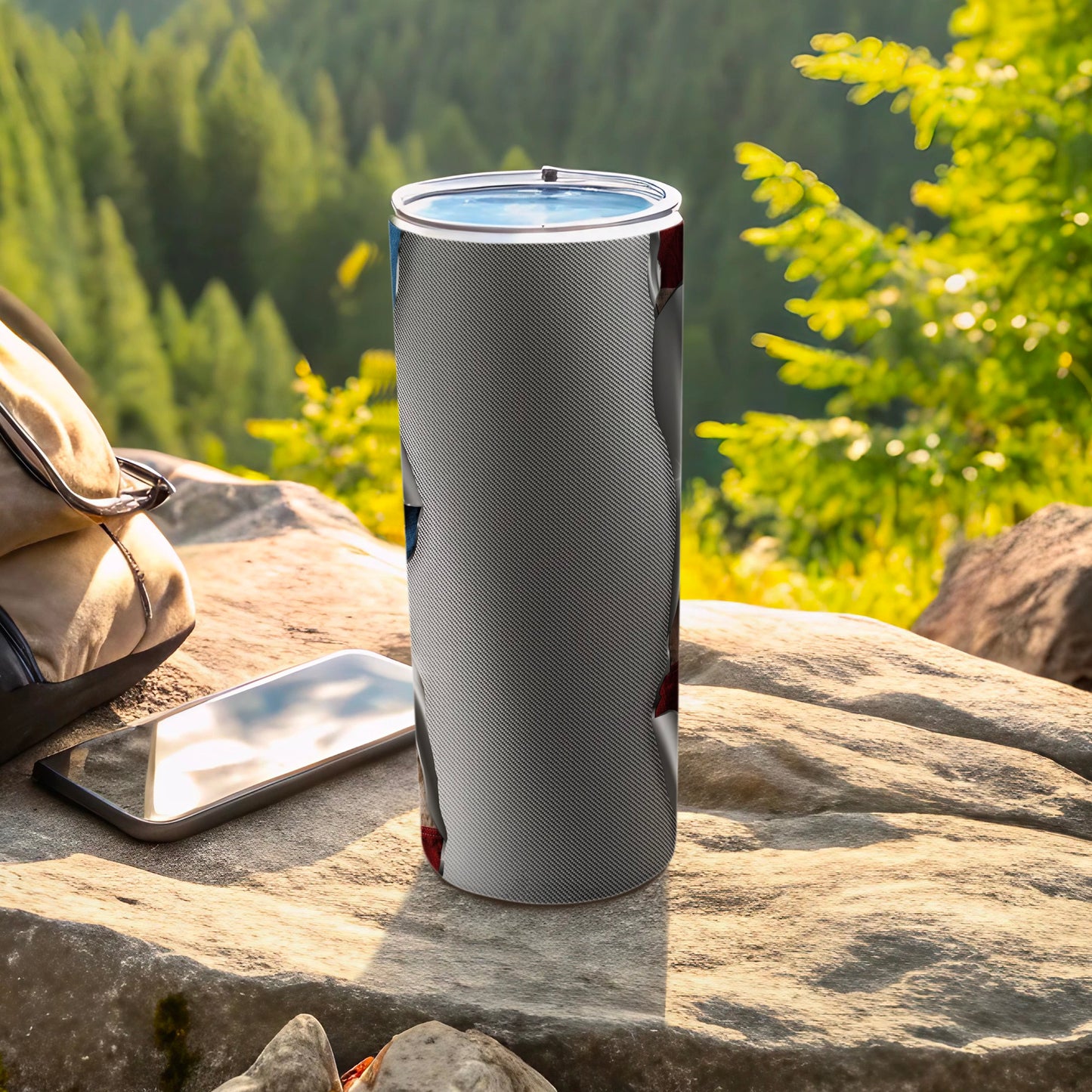 Tumbler with a patterned exterior and American flag design, next to a phone and bag.