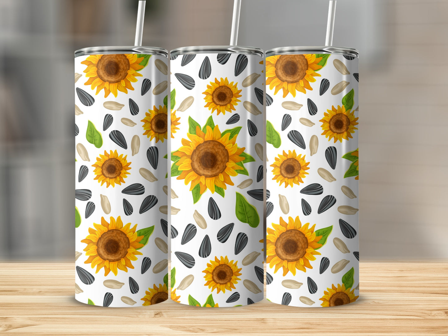 Three tumblers with sunflowers and seeds pattern on white background.