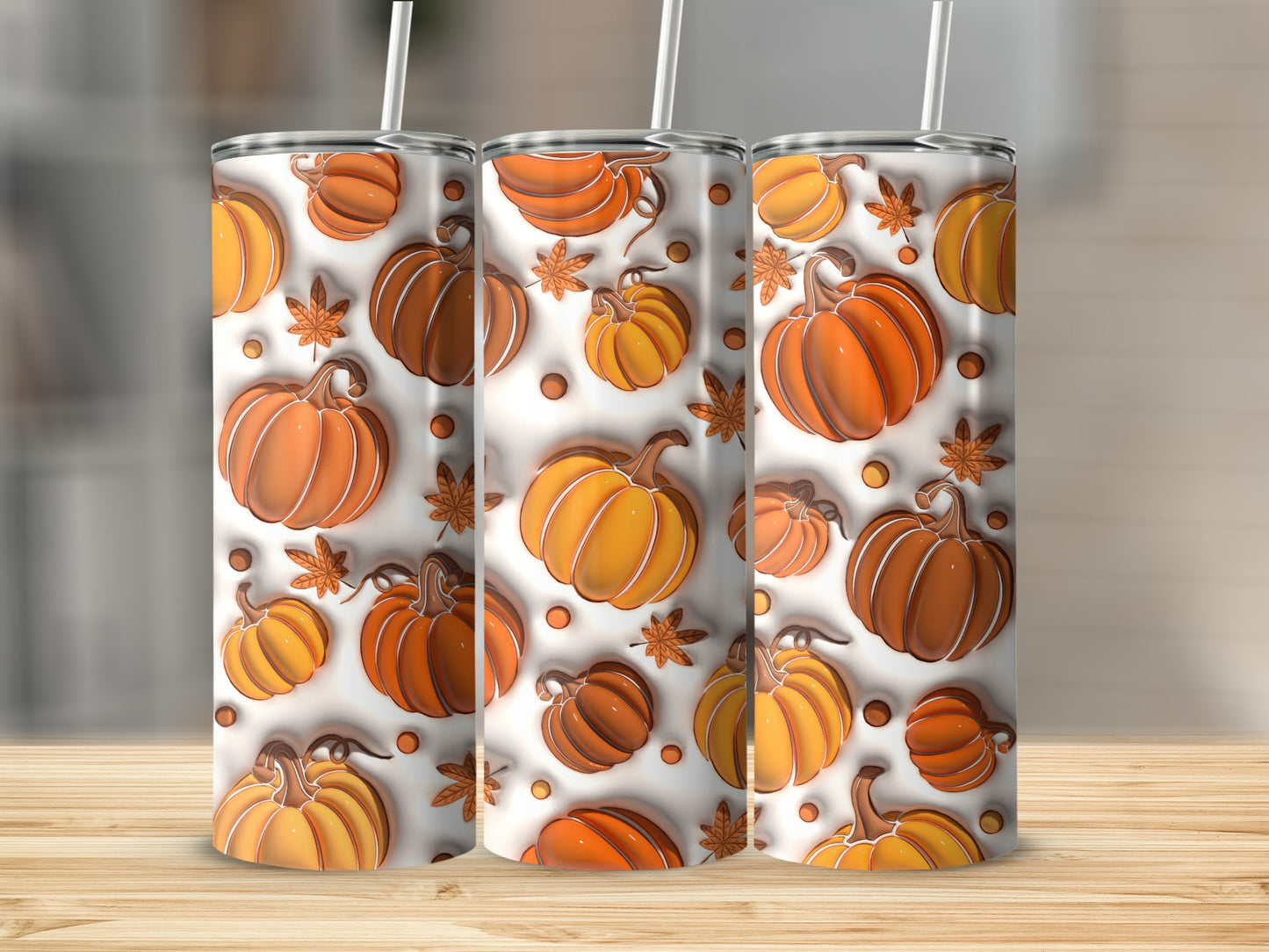 Three tumblers with a pumpkin and leaf pattern.