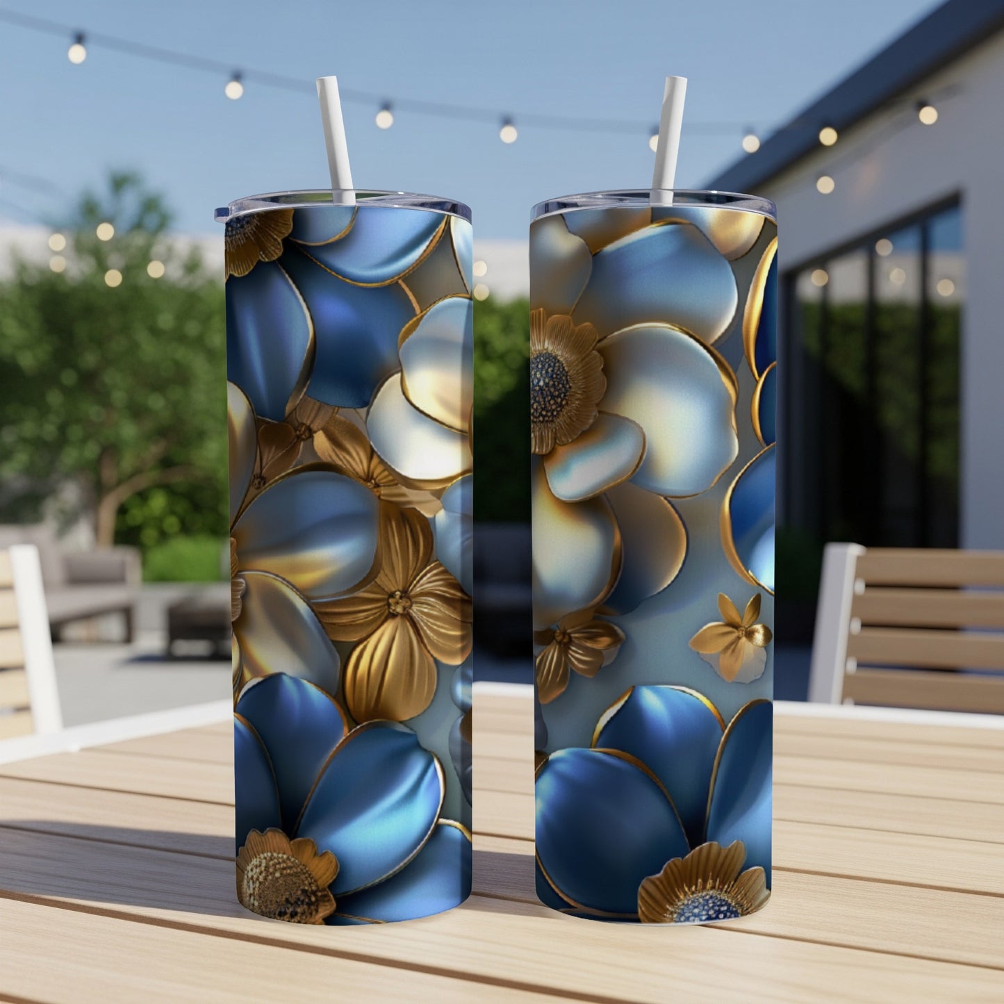 Two tall tumblers with blue and gold floral design on outdoor table.