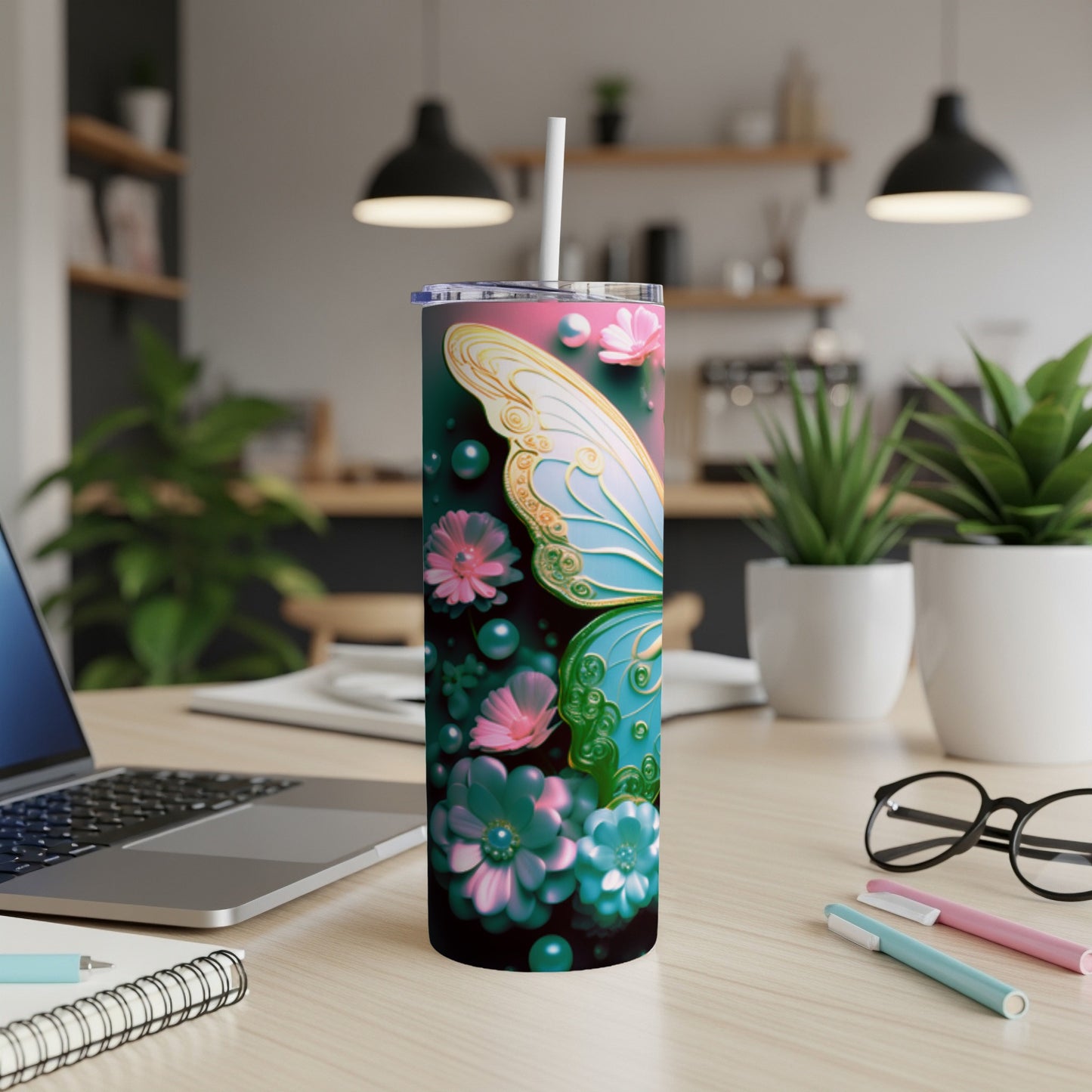 Pink and blue butterfly wings on a floral patterned tumbler with a straw.