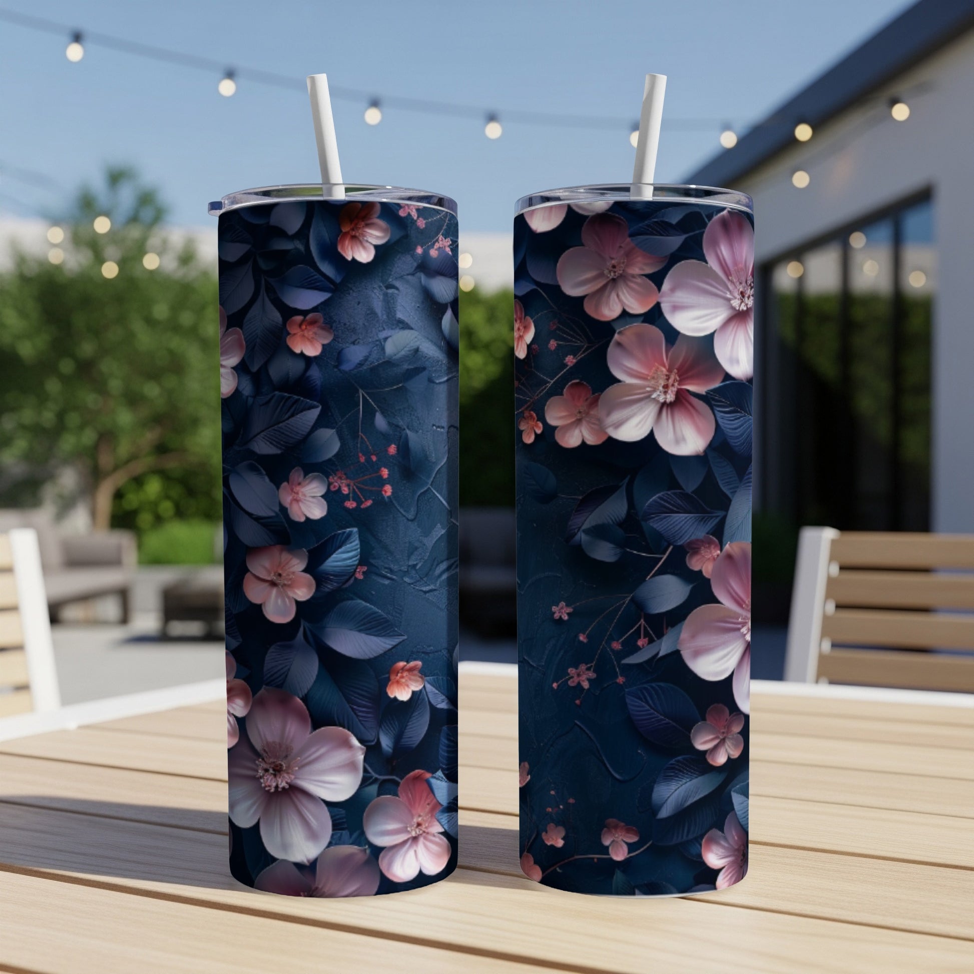 Two dark blue tumblers with pink and white floral patterns on a wooden table.
