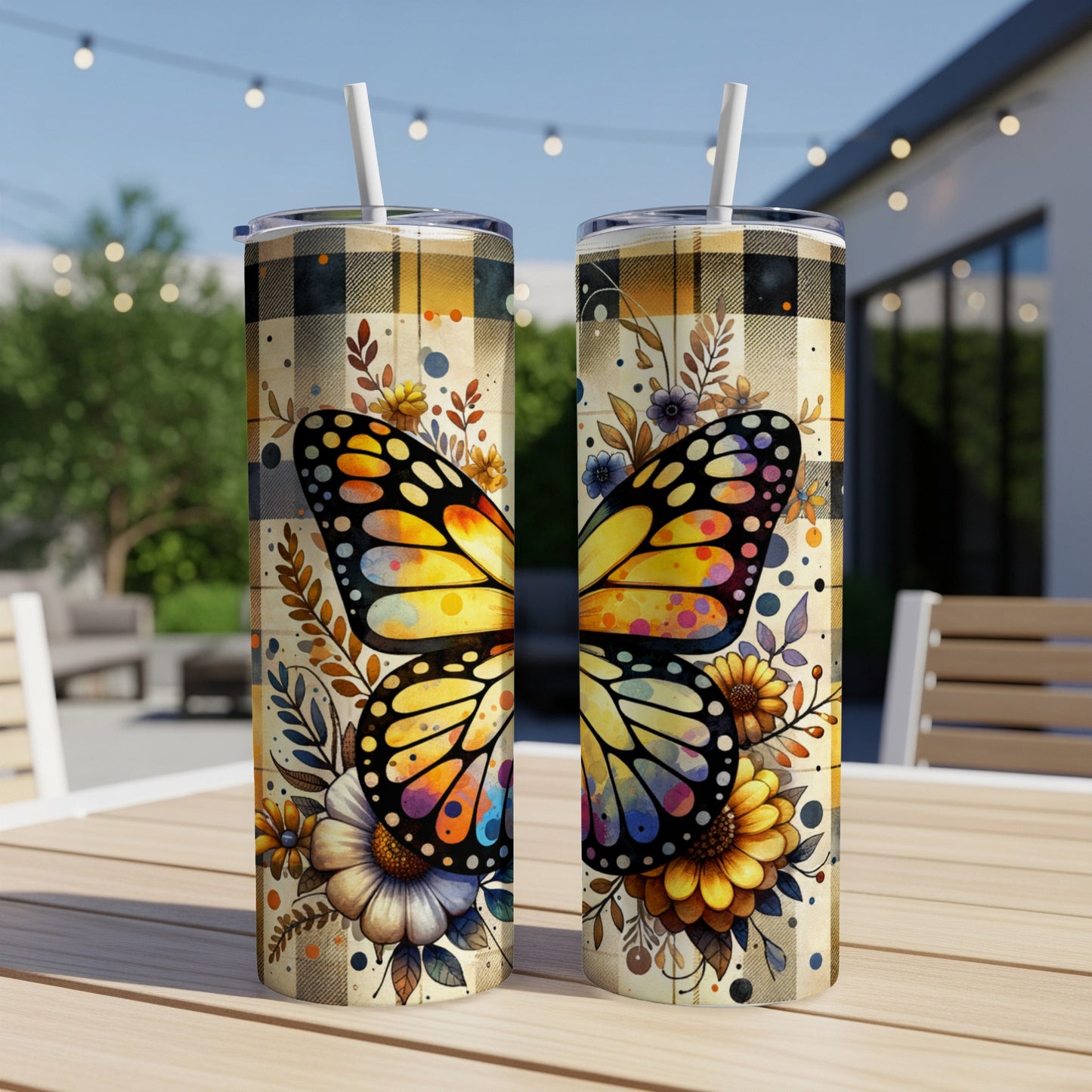 Two tumblers with butterfly and floral designs on a plaid background.