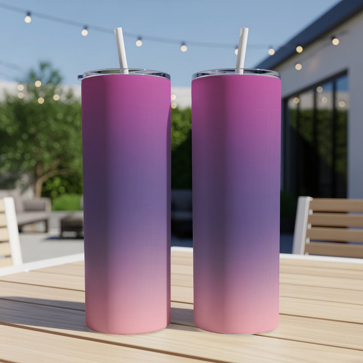 Two tall tumblers with a pink to purple gradient, on a table.