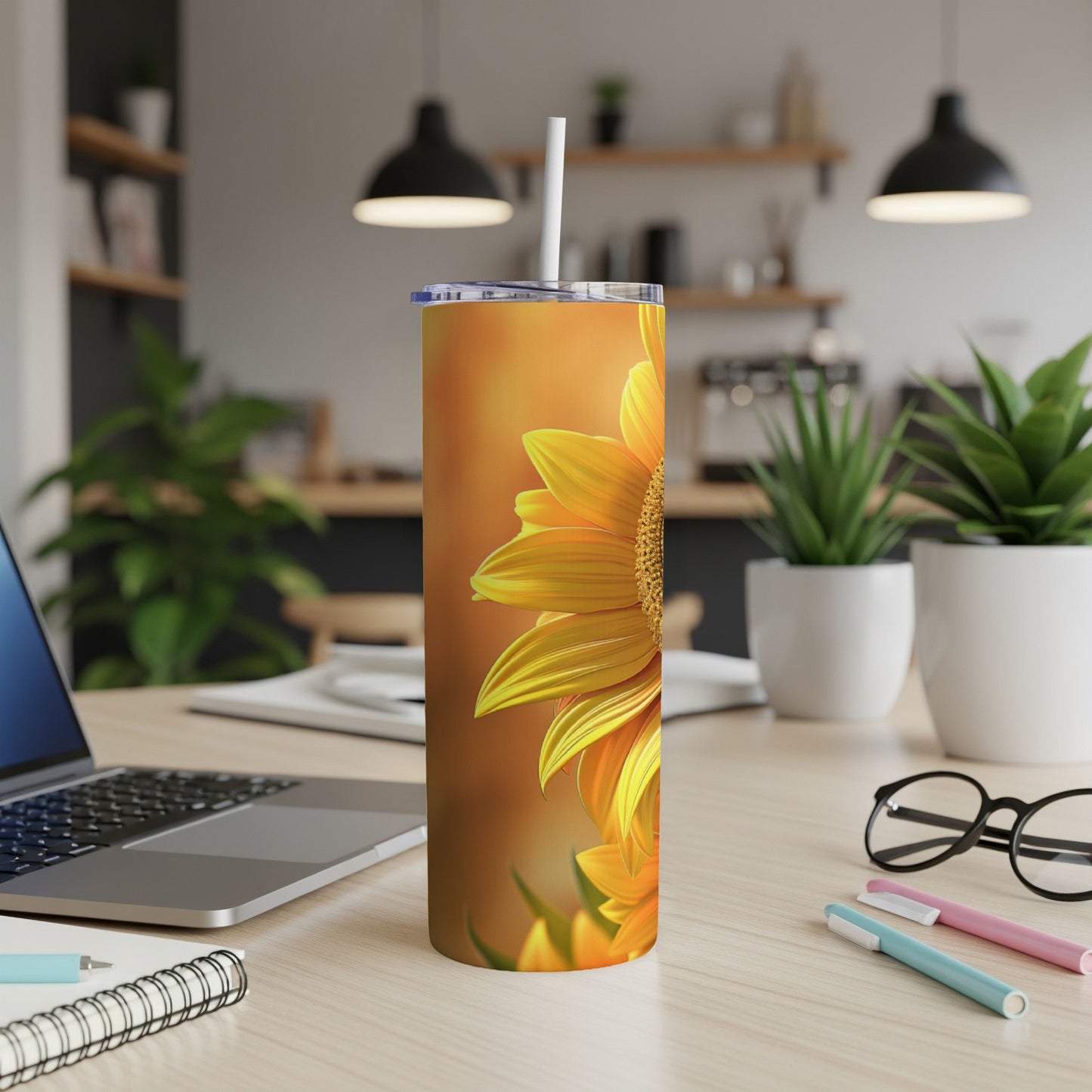 Tall tumbler with close-up sunflower on a desk with laptop.