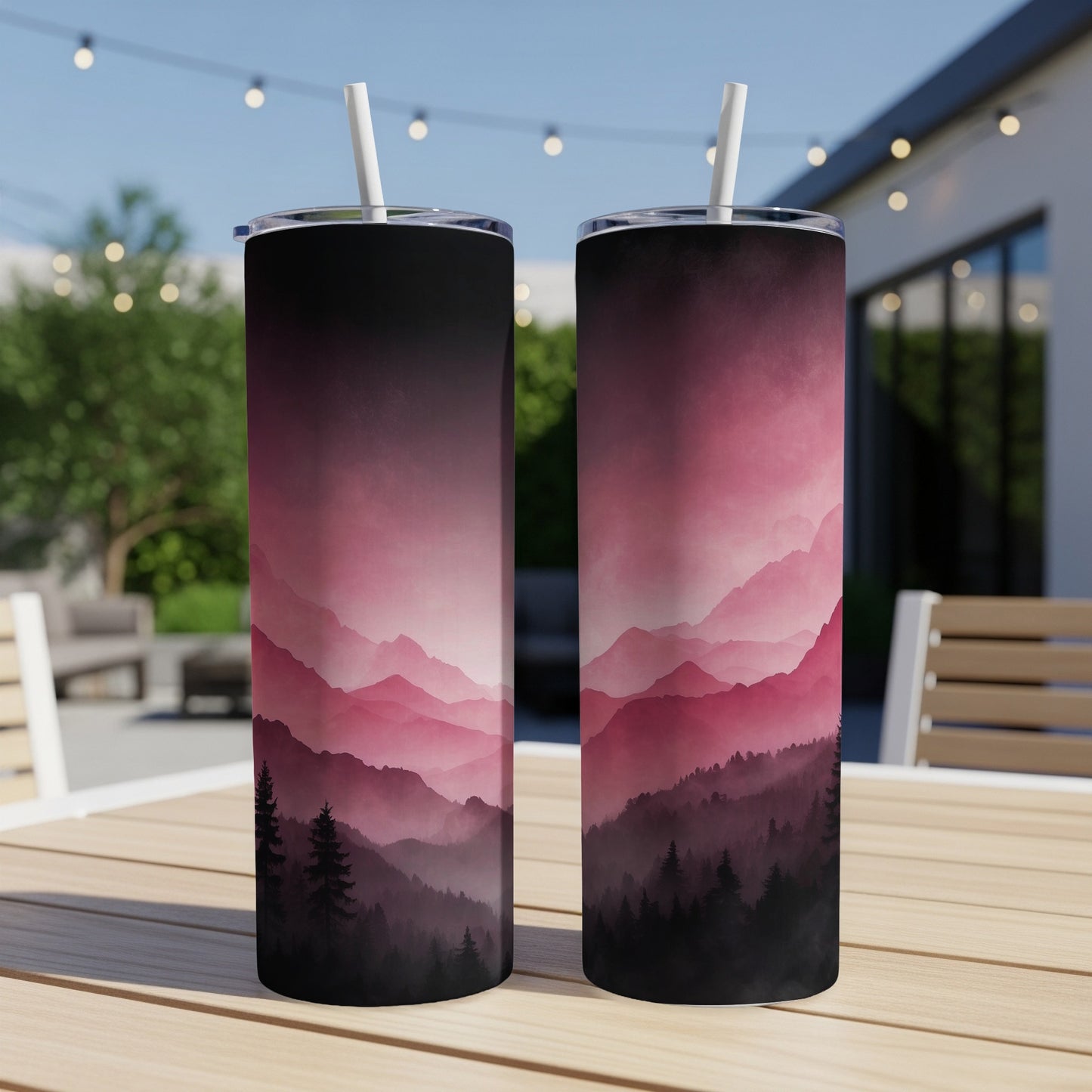 Two pink and black gradient mountain forest tumblers on a wooden table.