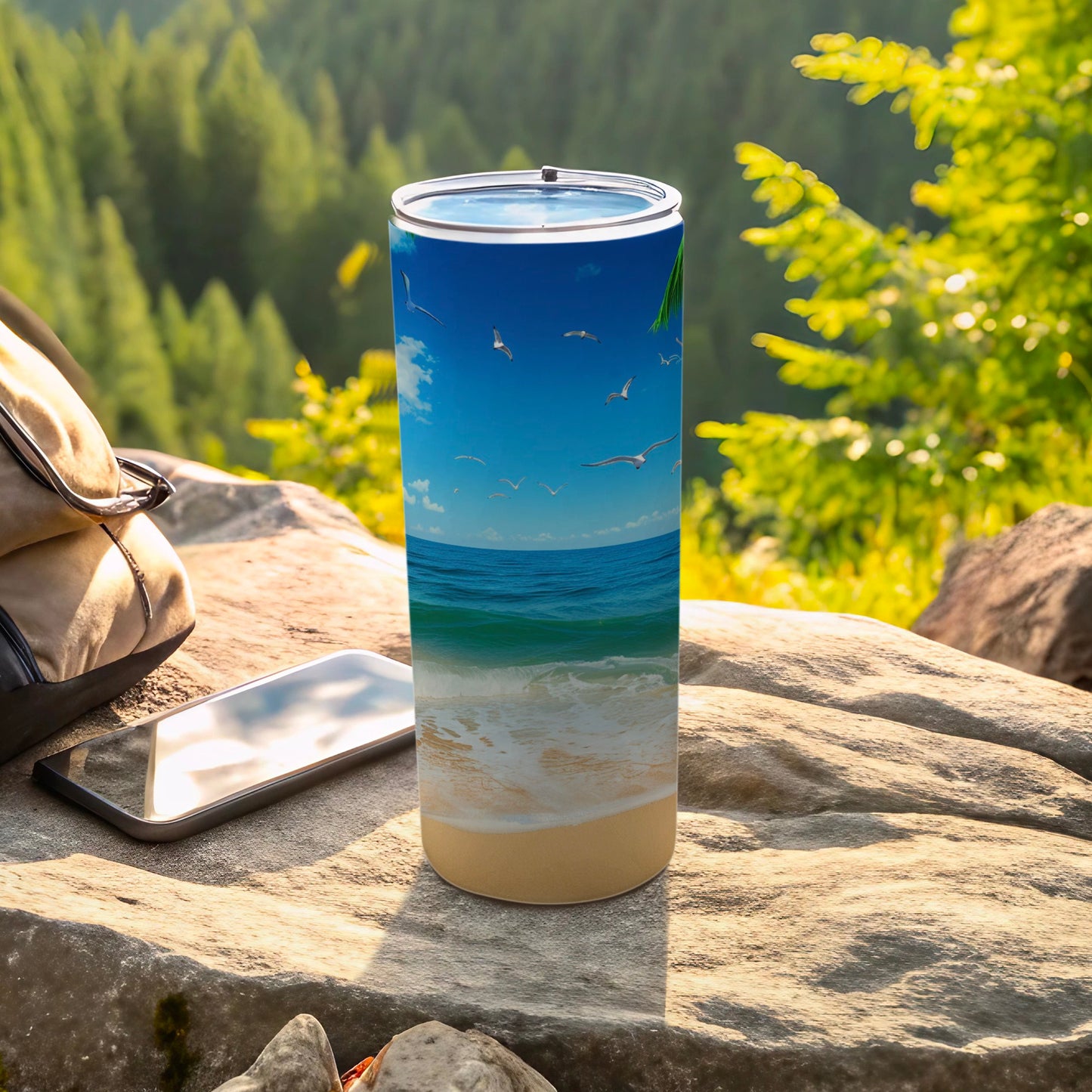 Beach scene with seagulls on a tumbler next to a backpack and phone.