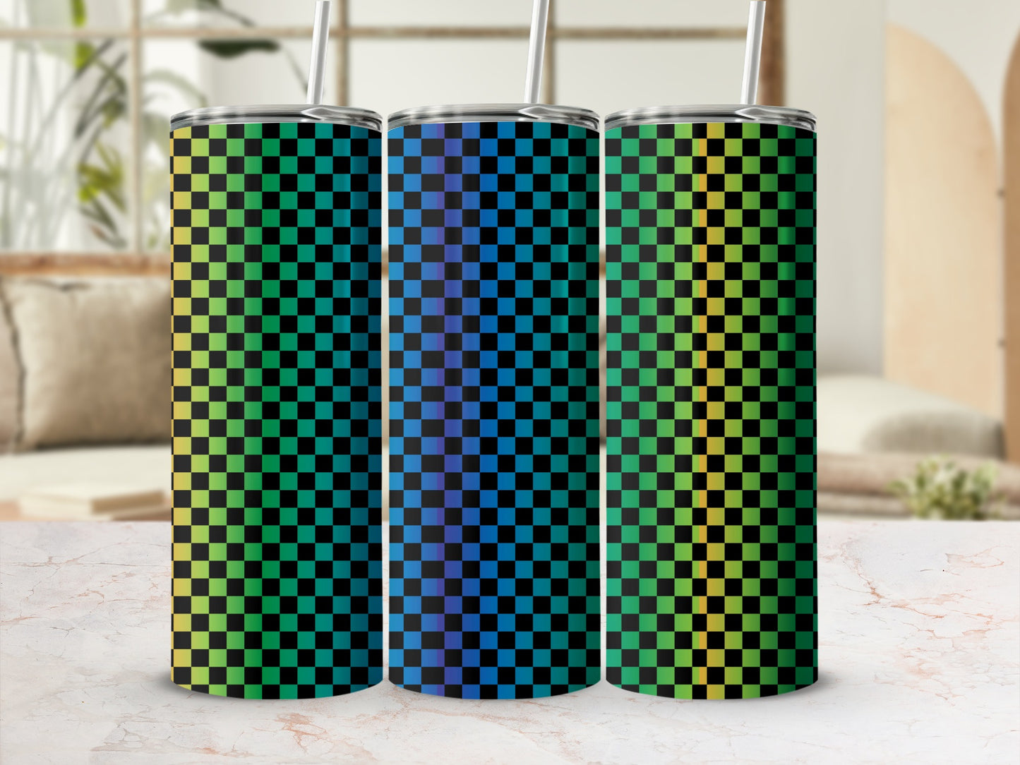 Three gradient checkered tumblers with straws on a marble surface.