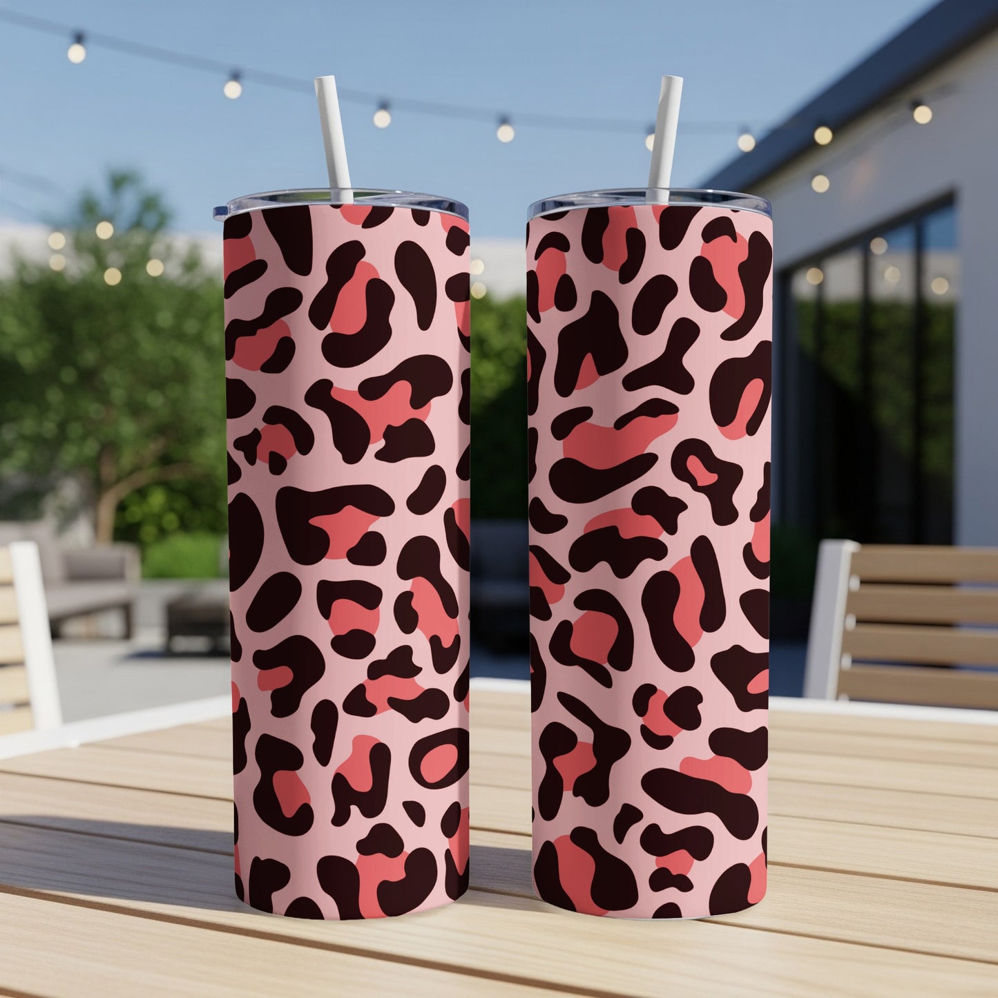 Two pink tumblers with brown and coral leopard print and white straws.
