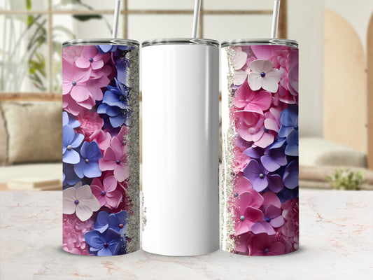 White tumbler with pink and blue floral design and glitter accents.