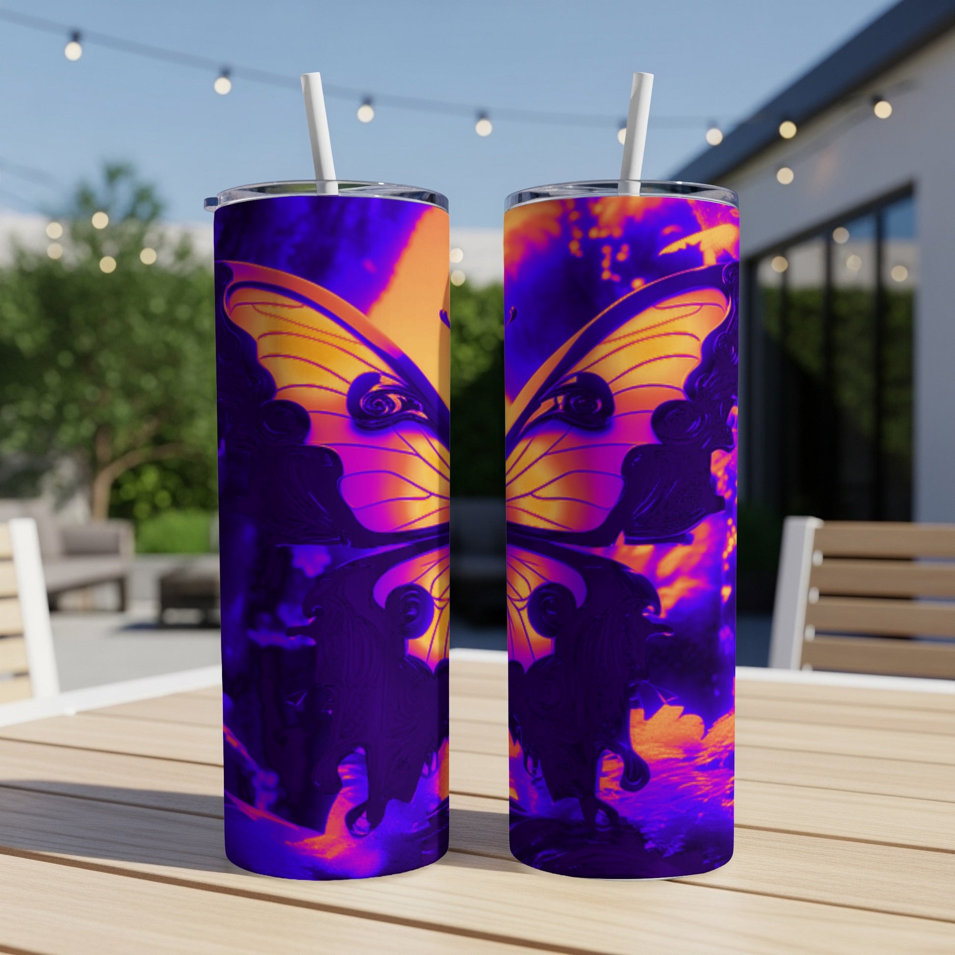 Two purple and orange abstract butterfly patterned tumblers with straws on a table.